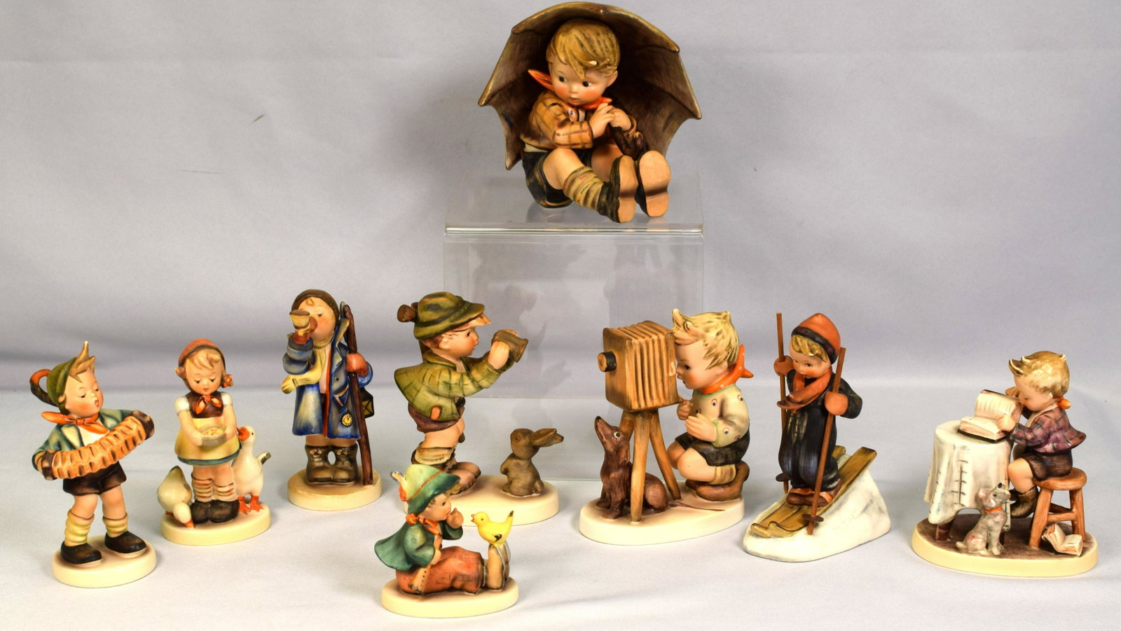 GROUPING HUMMELS FIGURE GROUPING: Consists of 1) Number 178, 5 inches tall, Photographer. Small bee. Good condition. 2) Number #306. Little bookeeper. 4 1/2 inches. Small bee. Good condition. 3) Number #15/0, Hear Ye Hear Ye.5 inches 