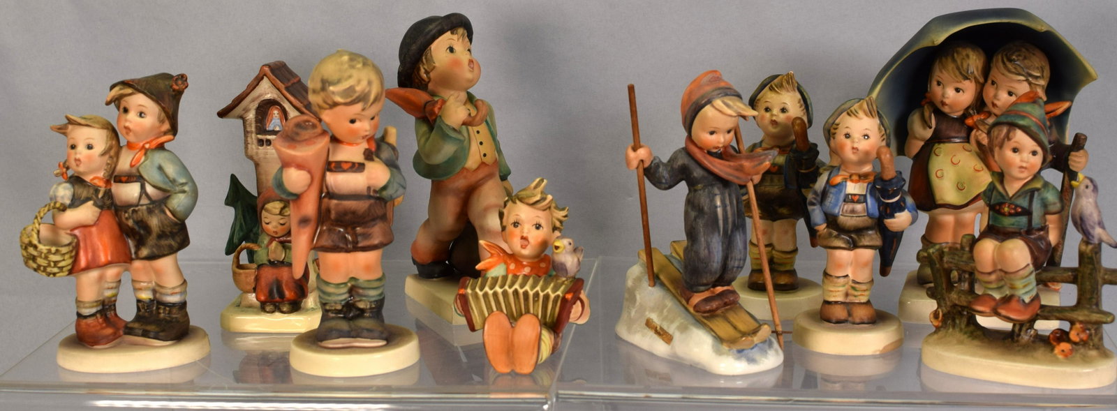 SET OF 10 HUMMEL FIGURINES: Set includes; 1.) #71 "Stormy Weather" 5 3/4in tall, good condition. 2.) (Set of 2) #198 2/0 "Home From Market" 4 3/4in tall, good condition. 3.) #110/0 "Let's Sing" 3 1/4in tall, goodcondition. 4.) #