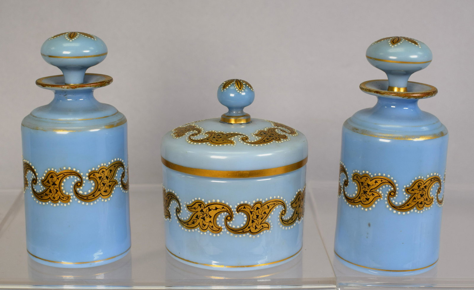 SET OF 3 BLUE OPALINE DRESSER BOTTLES: 3 blue opaline dresser bottles with enamel decoration across the top and mid section. All have bottom polished pontils. All in good condition, 5 1/2in x 4 1/2in x 5 1/2in, 2lbs.