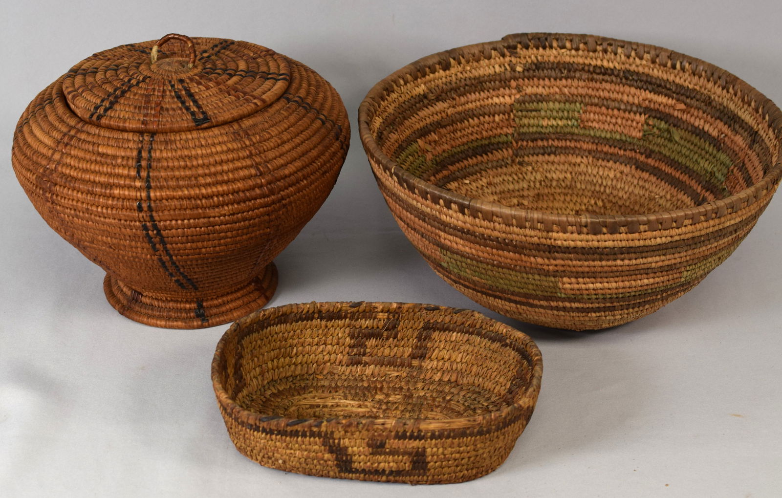 (on-3) NATIVE AMERICAN COIL INDIAN BASKETS: Consists of 3 hand woven antique basket. 1) Salish basket with lid with false embroidery. Ca 1900-1910. 10 inches diameter x 7 1/2 inches tall. Good condition. 2) Old Southern Arizona wovenbasket tray