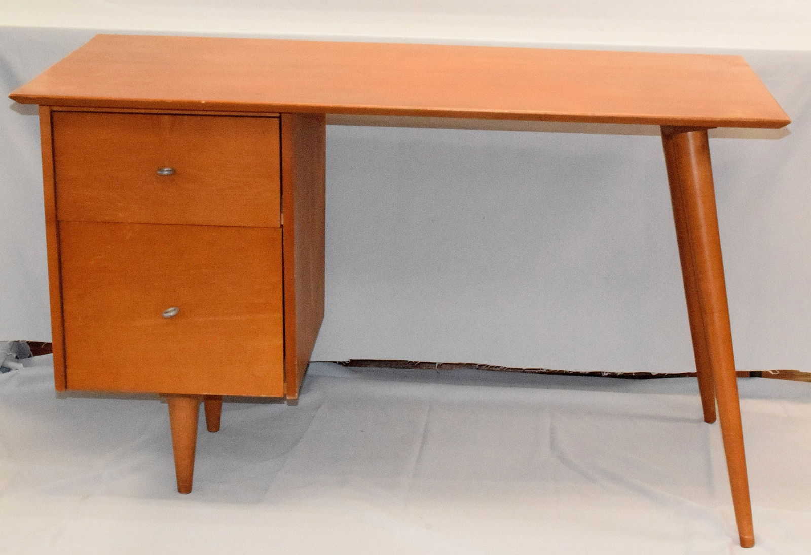PAUL MC COBB PLANNER GROUP DESK: Paul Mc Cobb Mid-century desk. Paul W McCobb (1917 - 1969) was active/lived in United States. Paul McCobb is known for Sculpture. Two drawers with aluminum ring pulls above centered tapered legs.Long