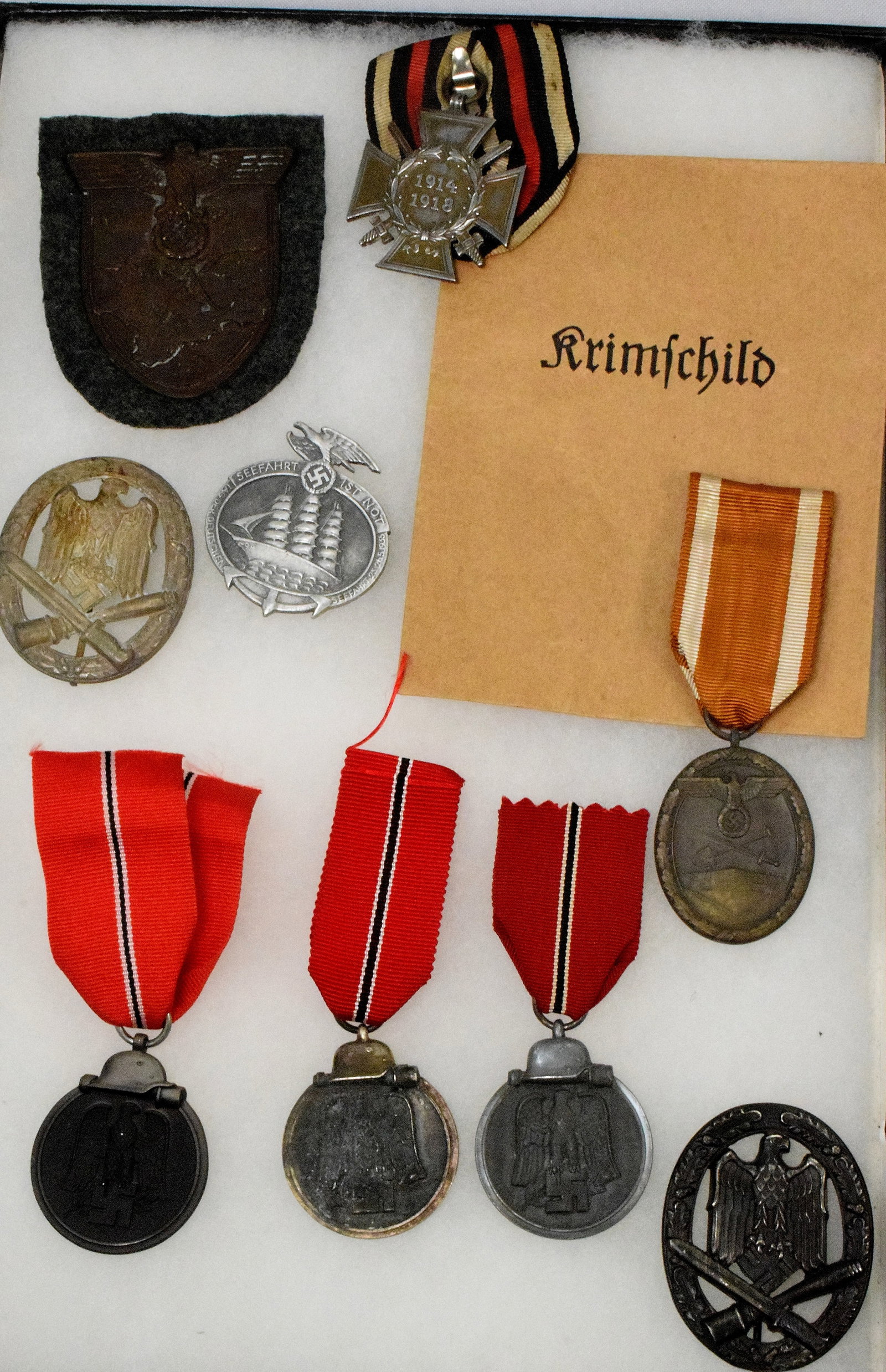 NINE GERMAN MEDALS: Estate collection of William Bureau of WWII Third Reich Military. Includes: 1) Krim Sleeve Shield Award 2.) One WW1 Hindenburg Honor Cross, dates 1914 - 1918. 3.) One 1935 Seefarth Ist Not Tag Der Deu