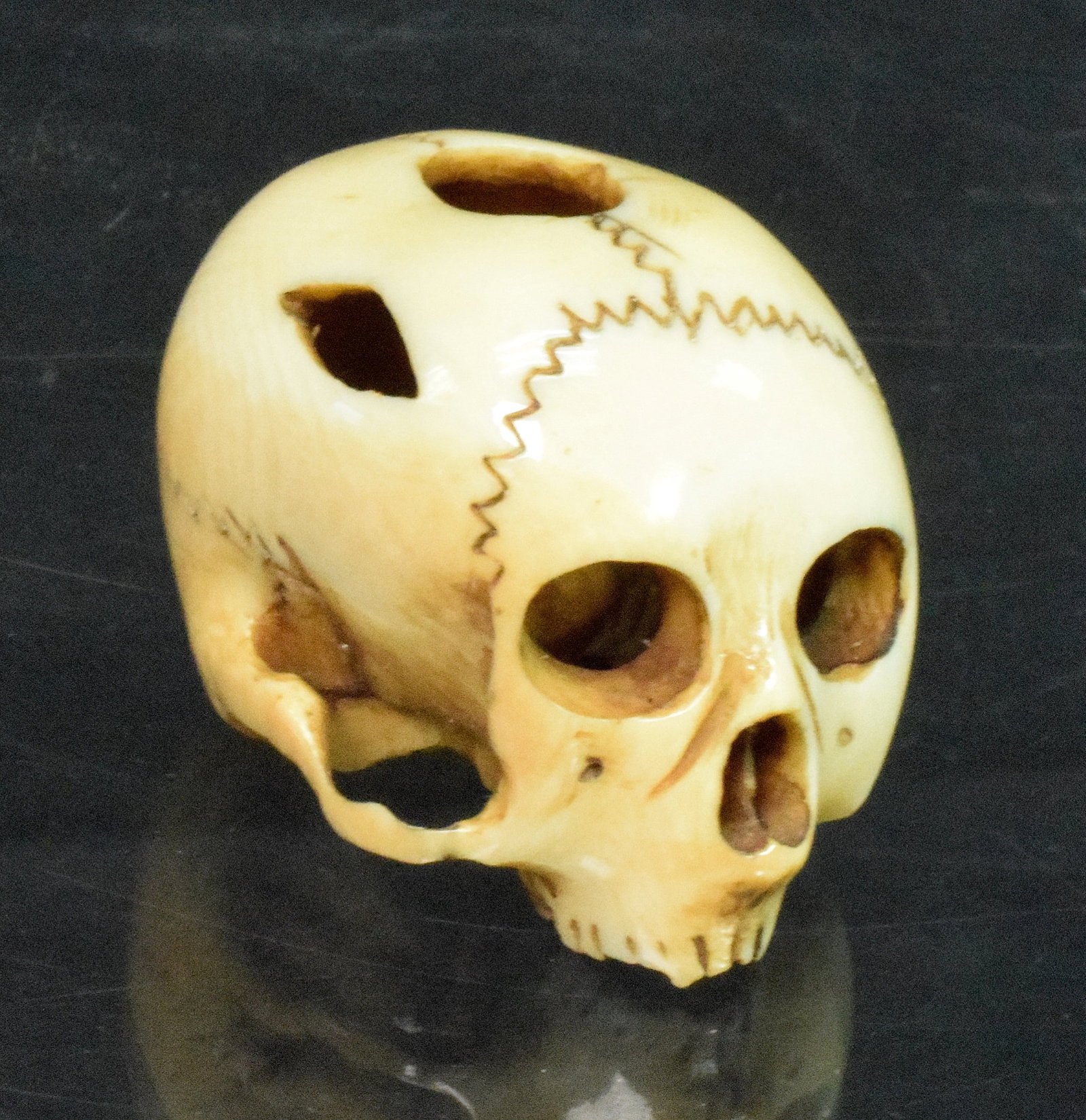 JAPANESE CARVED NETSUKE SKULL: Ca 1920's. Japanese netsuke in the shape of a skull, beautifully detailed,carved bone. Good condition. Measures approx. 1.5 inches x 1 inch. Weighs approx. 1 lb. This item must be picked upin Massachu