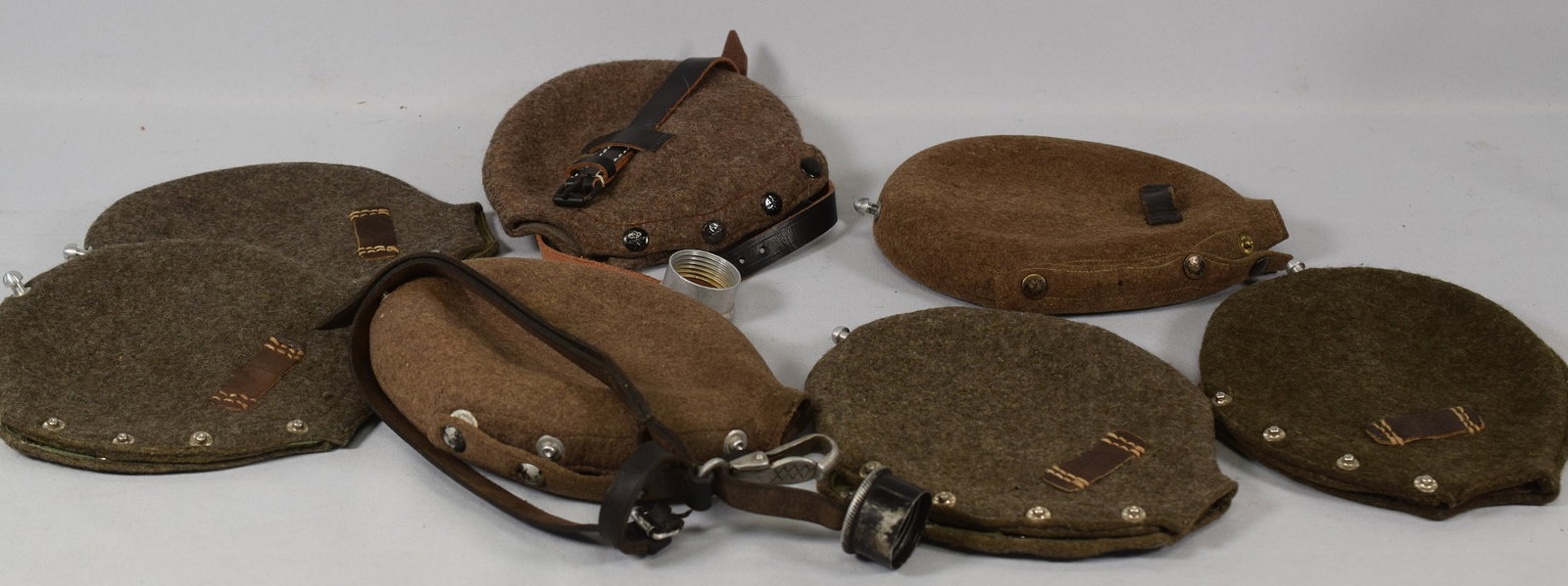 WWII GERMAN CANTEEN POUCHES: Estate collection of William Bureau of WWII Third Reich Military. Collection are antique, new, vintage, and reproductions pieces. Includes 7 WWII German canteen pouches. Two canteens have strapsattach