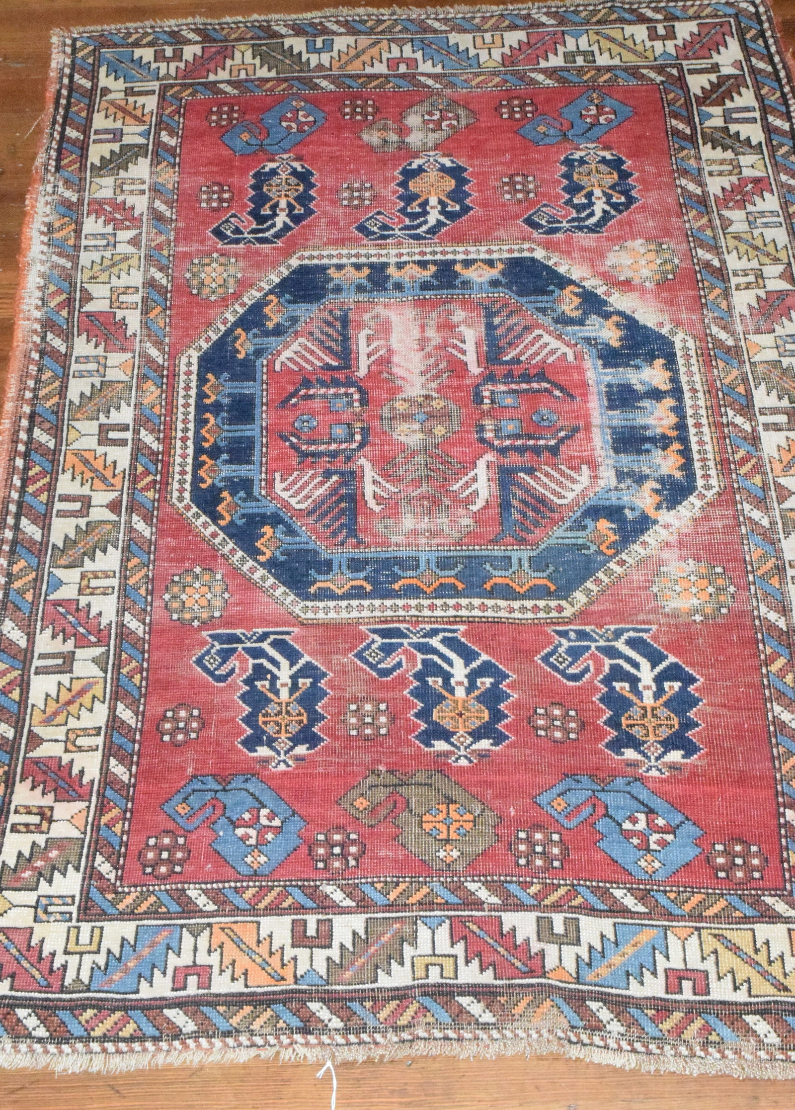 KAZAK AREA ORIENTAL RUG: Antique, red field, medallion on center, boarder patterns: wine cup and saw tooth. Low spots and wear for condition, Length 5/5, about 3/6 wide, shipping 6 pounds.