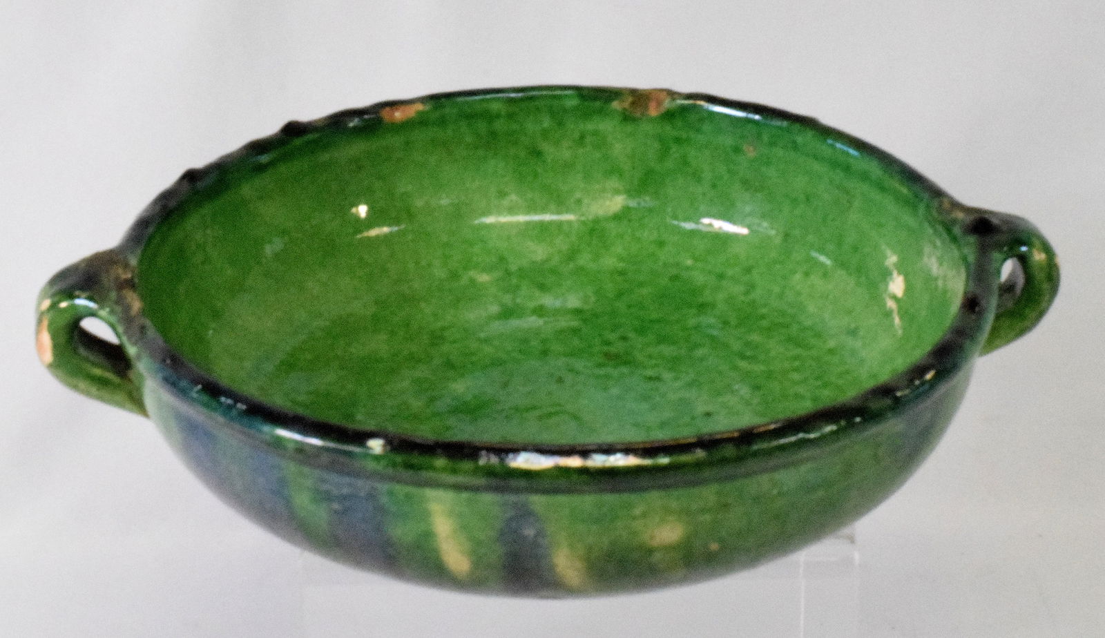 EARLY SOUTH EASTERN MASS MULTI-GLAZED REDWARE BOWL: Early attrib. South Eastern Massachusetts19th century handled redware pottery bowl. 9 1/2 inches diameter x 2 3/4 inches tall. Hand thrown. Multi glazed. Green and blue. South EasternMassachusetts est