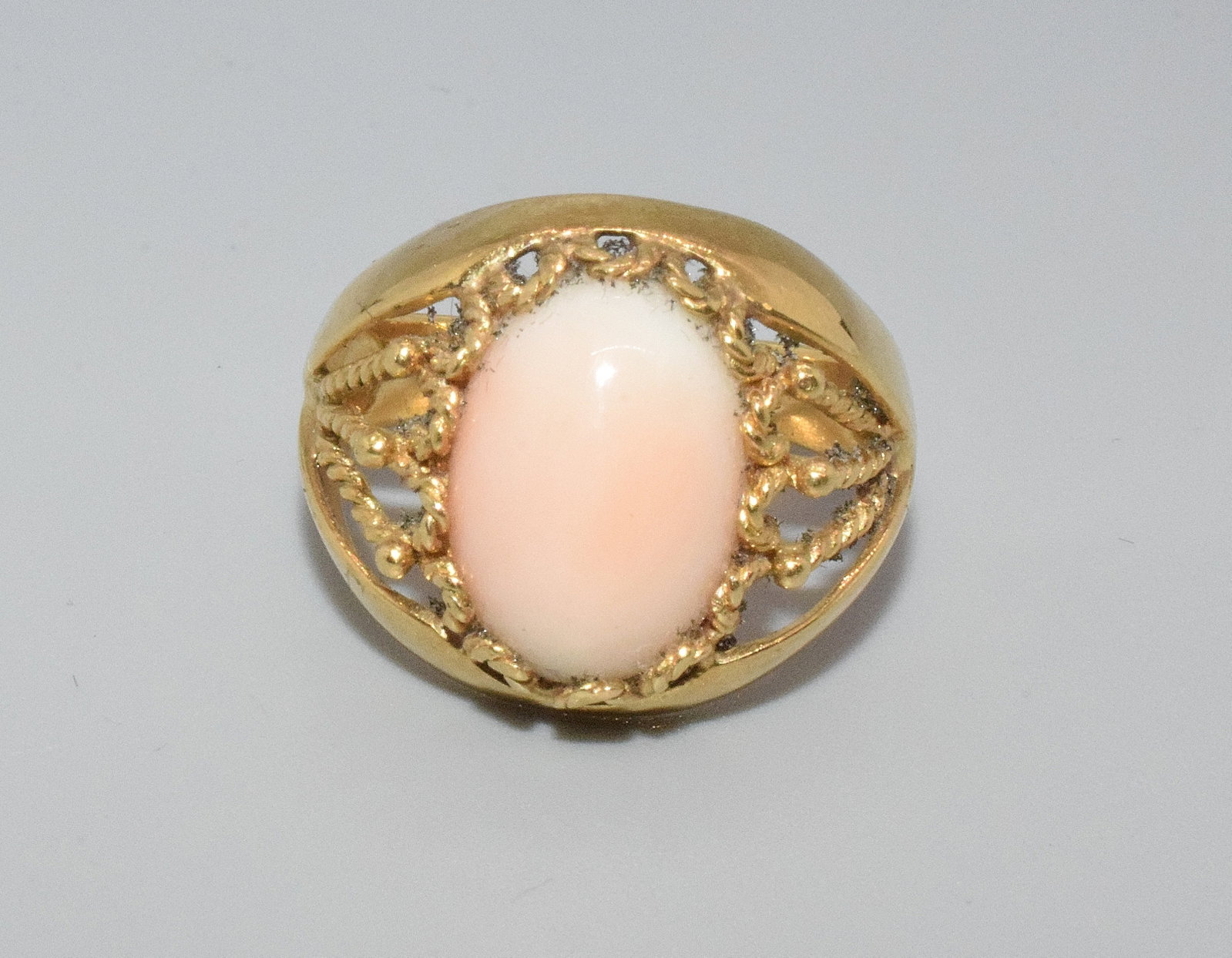 18K YELLOW GOLD & CABACHON CORAL RING: Marked was un-clear but tested 18k. Ring size 8. Coral approx. 11 milmeter. 4 DWT. Good condition. Whites auctions will not take credit cards on gold jewelry and does not grade coins.