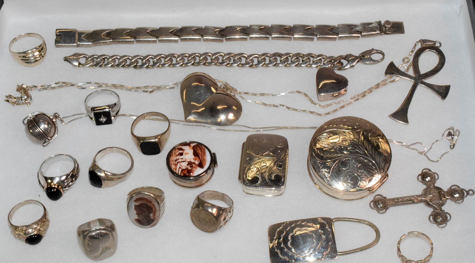 21 ASSEMBLED STERLING SILVER JEWELRY PIECES.: Consists of all marked pieces. 1) 10 rings. Of note one with cabochon onyx and 14k gold bezel. 2) 4 pill boxes. one with enamel dogs. 3) 2 bracelets. 4) 2 crosses. One with chain. 5) Heartpendant. 6)