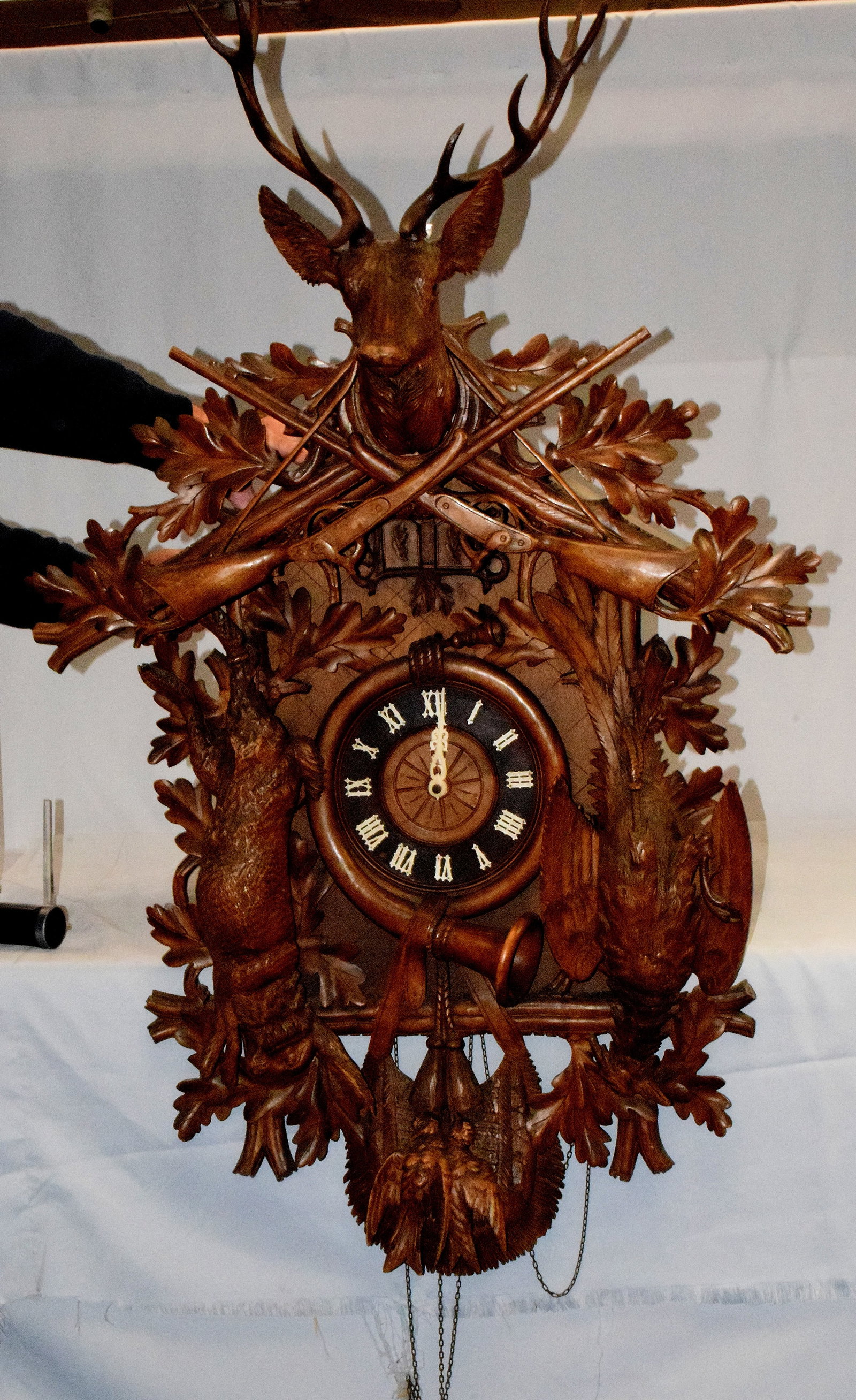 QUAIL BLACK FOREST CARVED WALNUT CUCKOO CLOCK: Large wonderful 48 inch 19th/20th century German black forest carved cuckoo wall clock. 30 hour clock. Brass movement. All hand carved. Stag carved in crest with antlers. 2 hanging Long Guns, Game sce
