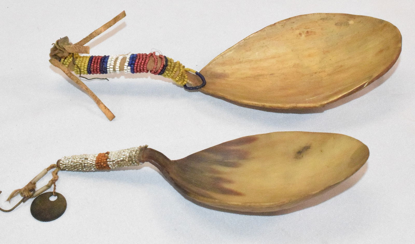 (2) PLAINS HORN SPOONS WITH BEADED WRAPPED HANDLES: Ca 19th/20th. Plains Horn Spoons, with Bead Wrapped Handles. One marked Xmas 1905. One Good condition. Untouched. 7 1/2 inches long. This one has been damaged. Glued piece. 8 1/2 inches. Visable in ph