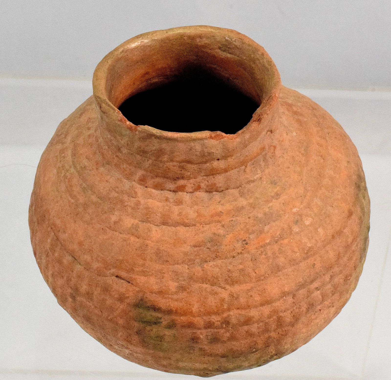 ANCIENT NATIVE AMERICAN TULAROSA CORRUGATED POT: Ancestral Pueblo corrugated olla pot. Small terracotta, bulbous shape with raised neck. Measures 3 inches tall x approximately 3 inches wide. Chip on rim.