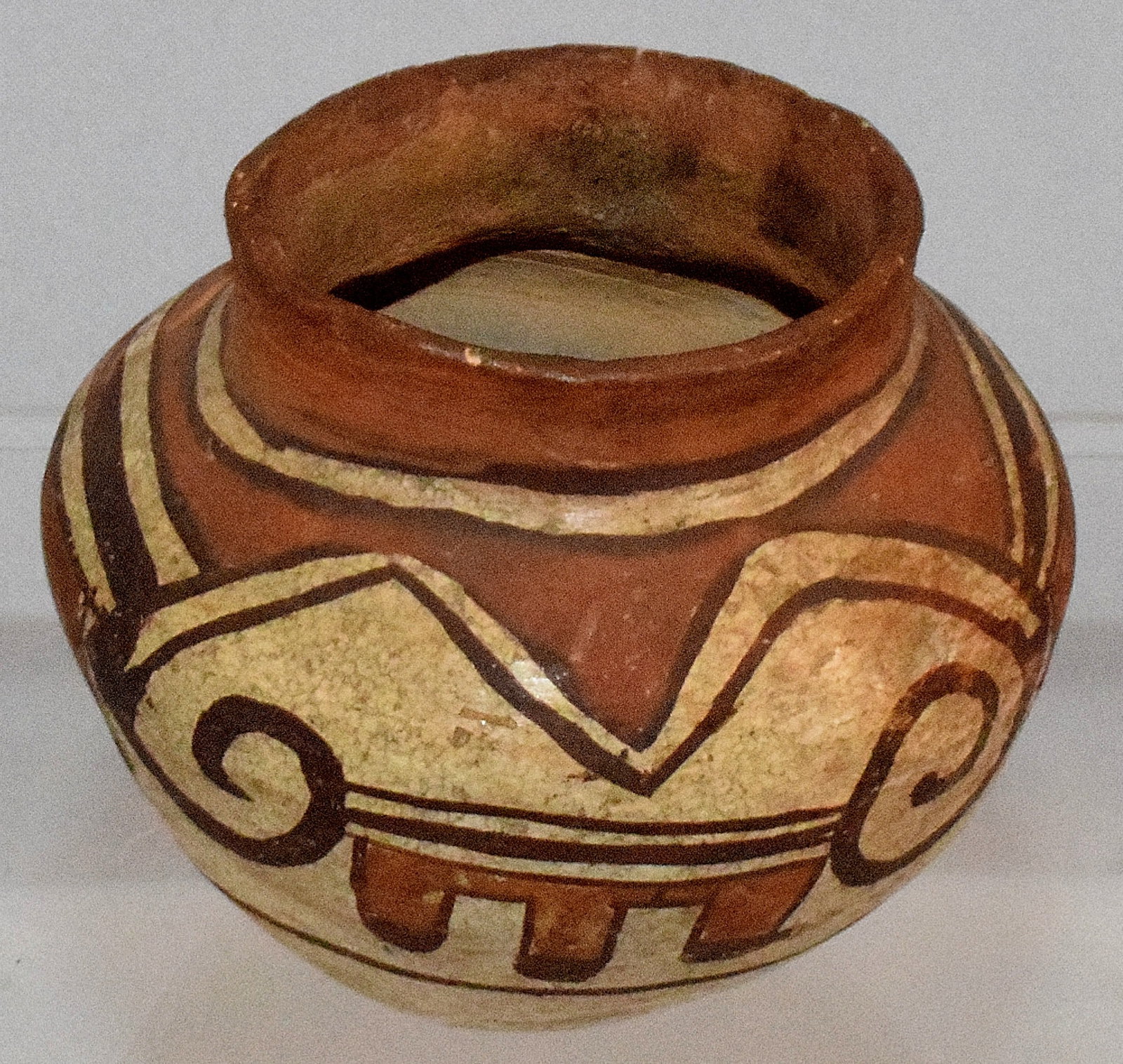 19TH HOPI SMALL POTTERY JAR OR VASE.: 19th Hopi Polacca or Acoma polychrome pottery jar. Squat form, hand painted with geometric designs. The neck with scalloped and bands. 2 1/2 inches tall. Various stuffs, craquelure and a hole inside t