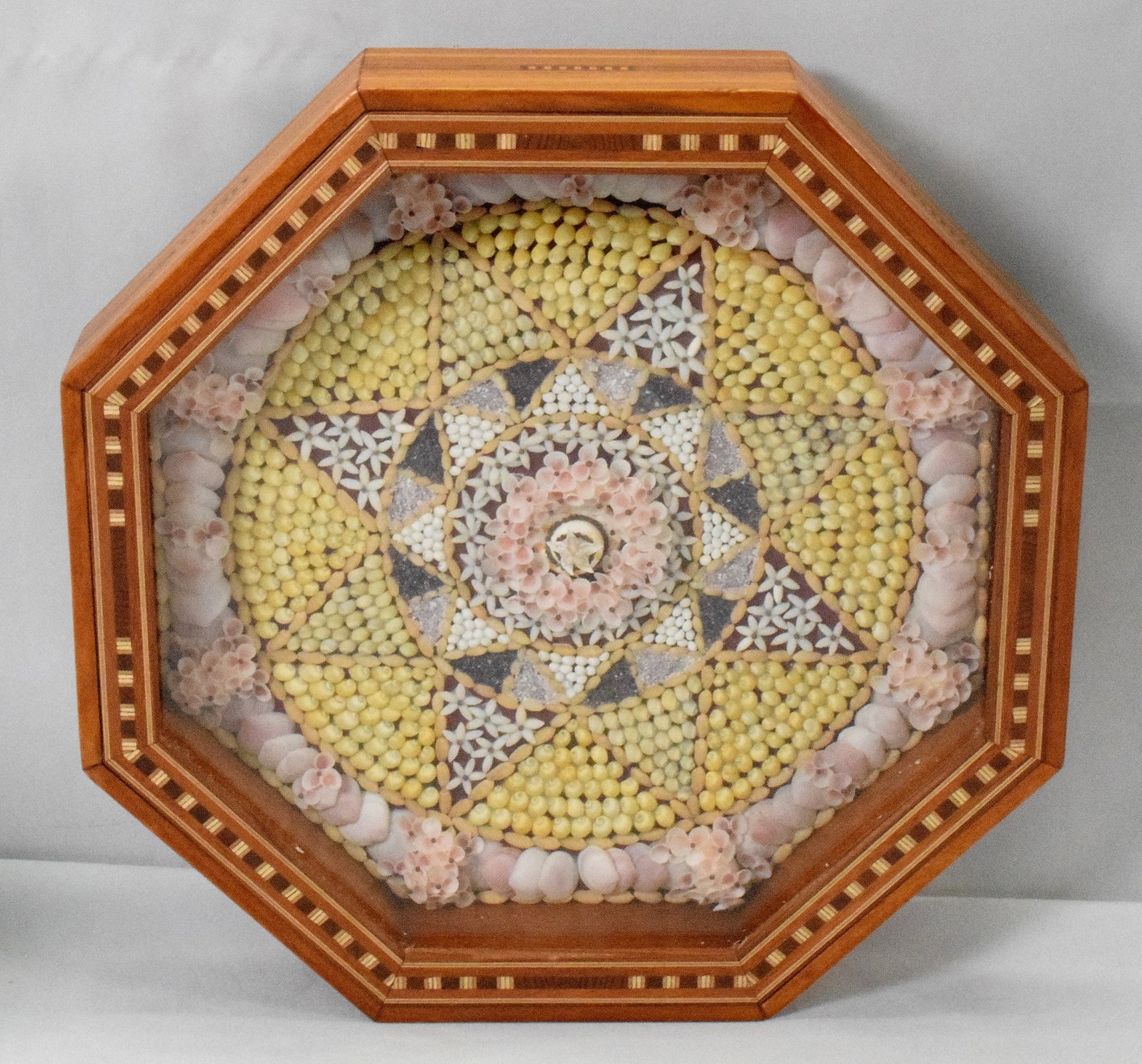 CONTEMPORARY SAILOR'S VALENTINE: Contemporary artist signed. Rosebud within a star Sailor's Valentine. Inlaid octagon case. 12 1/2 inches x 12 1/2 inches x 2 1/4 in tall. Signed and dated 2009 on back. Artist not identified. Good con