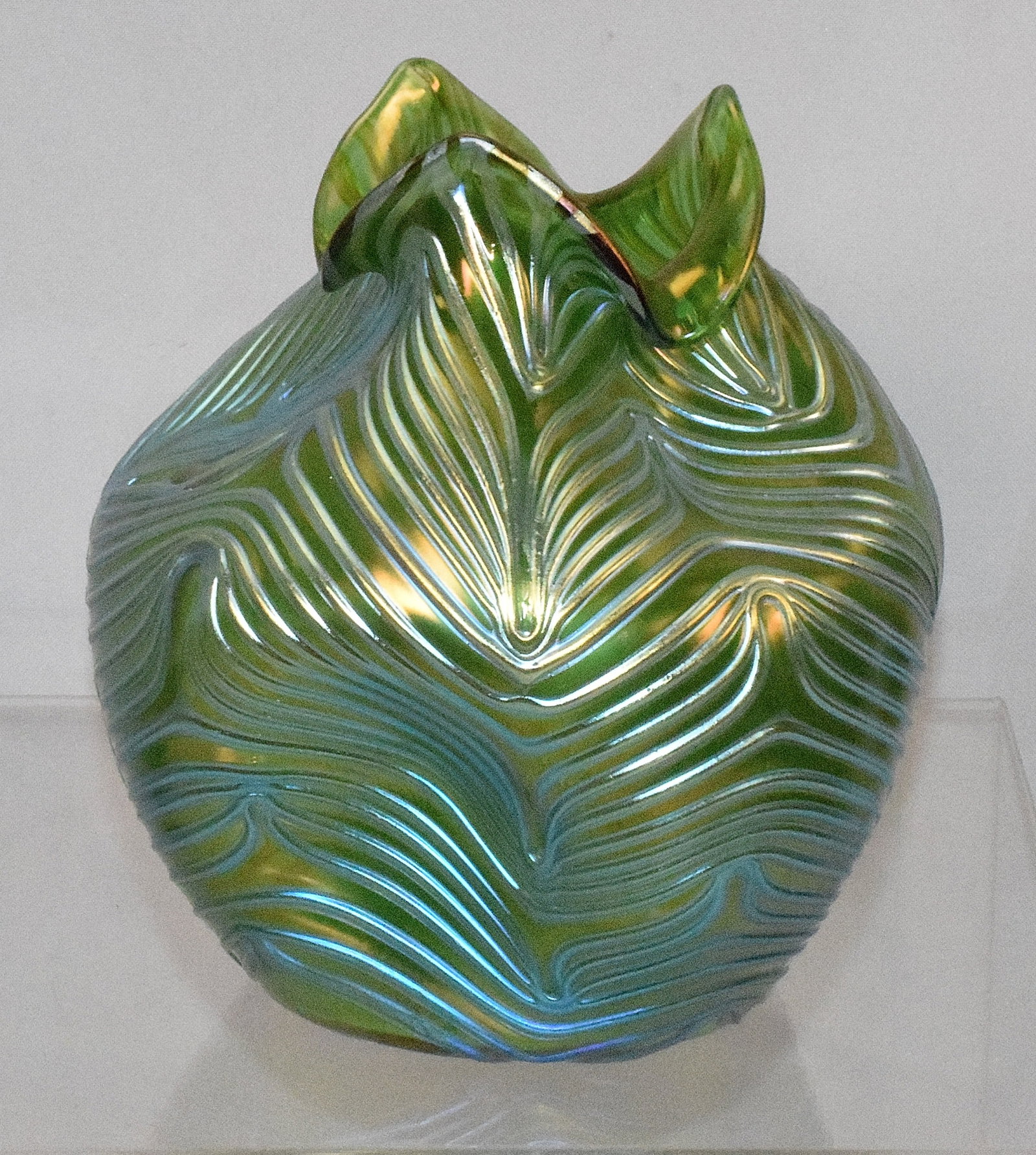 LOETZ 'CRETE FORMOSA' GLASS VASE C. 1905: Austrian Loetz Art Nouveau Crete Formosa art glass round vase with pinched sides and neck. Ruffled top. Translucent green with light blue iridescent threading overall. Pulled feather design. Ground po