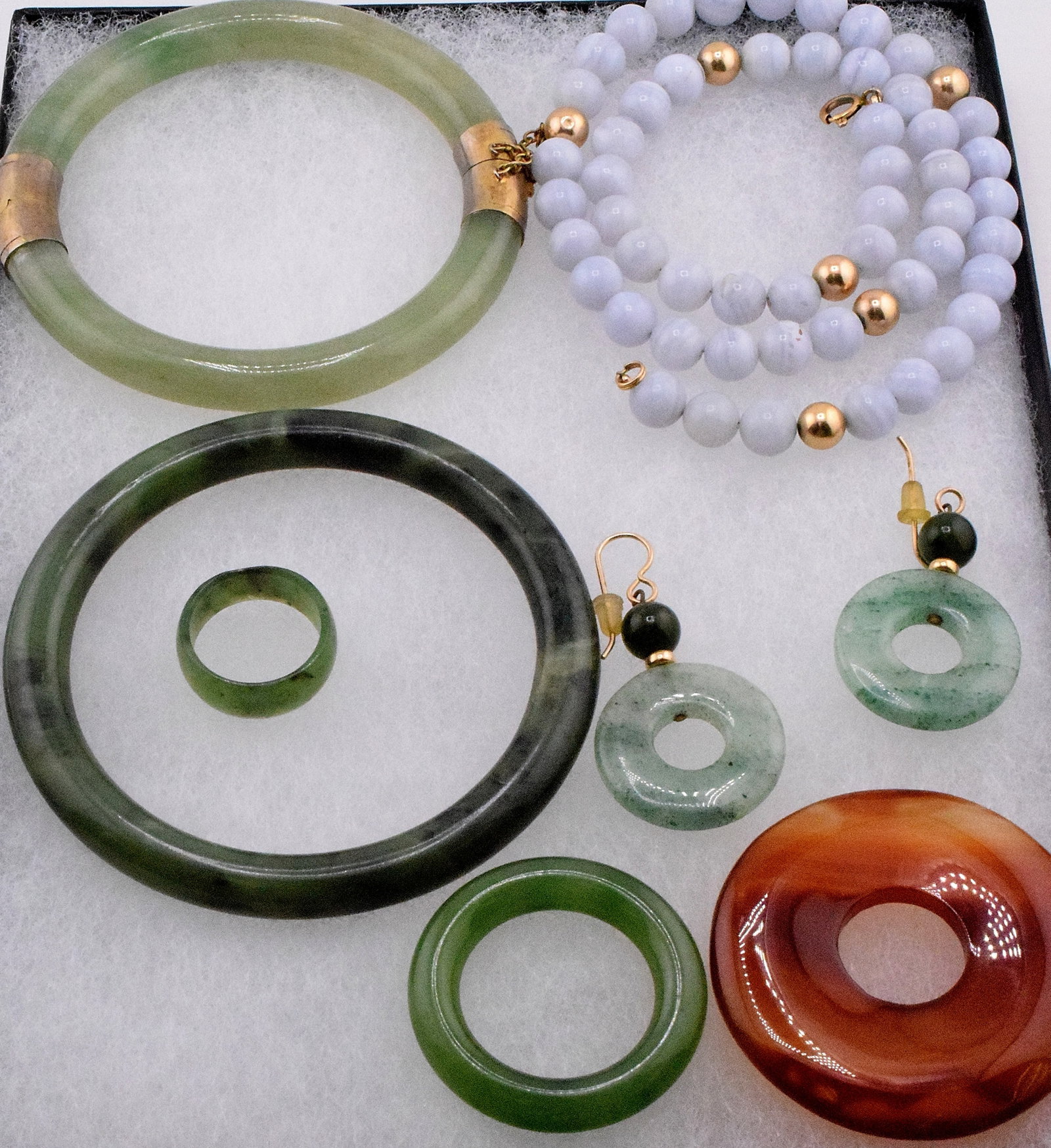 ASSEMBLED VINTAGE JADE JEWELRY GROUPING: Grouping of jade jewelry. 1) 2 bracelets, one with metal fittings. 2) Small ring. 3) Blue Lace agate beaded necklace with gold beads. 4) Circle of jade. 5) Pair of earrings, disk and bead. 6)Carnelian