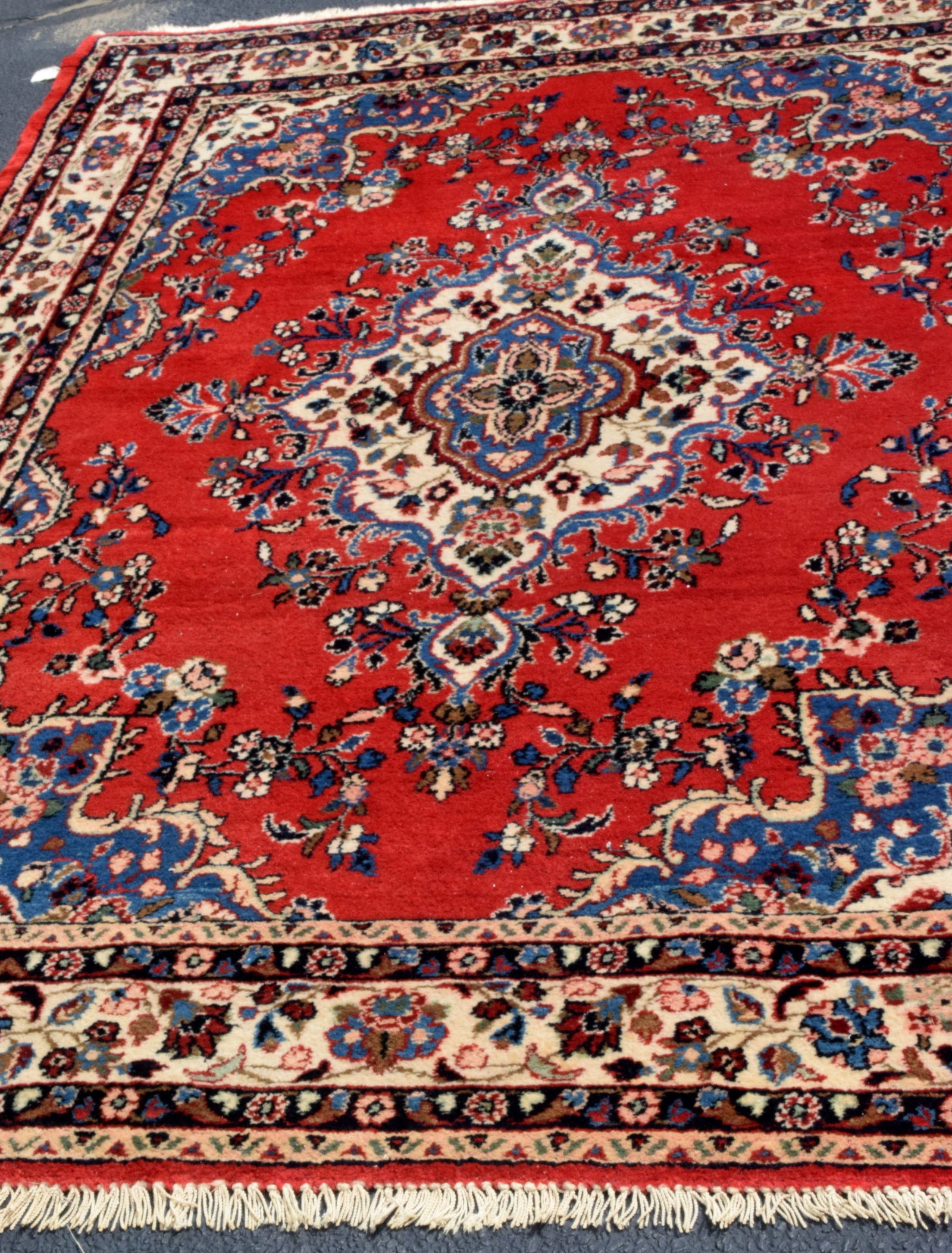 IRANIAN PERSIAN ORIENTAL RUG CA. 1960-1970: Iranian Persian Oriental hand woven wool rug with a medallion center, red field, floral border, and original fringe. 9'4 x 6'4 approximately 40 lbs.