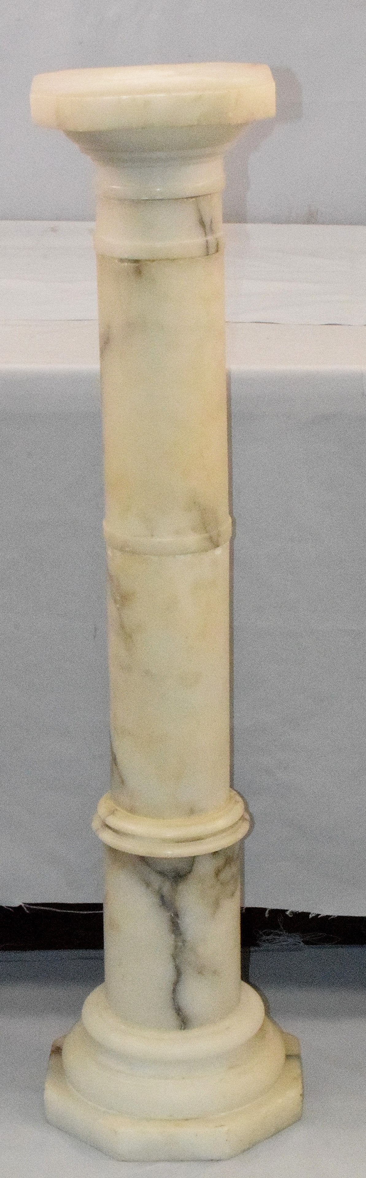 ANTIQUE ALABASTER PEDESTAL: Ca. 1900-1920's. Mottled white with black round column with banded accents. Square top with cut corners (8 sided). Stepped eight sided octagon base, approximately 11 inches. Height 40 3/4inches. Small