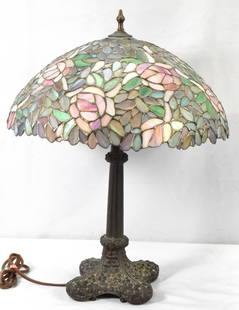 LEADED GLASS TABLE LAMP: Leaded glass table lamp. 24 inches tall with 18 inch shade. Shade with floral design. Heavy metal patina base. No marking. Age not known. Estate lamp. Working condition. Shipping weight Good condition