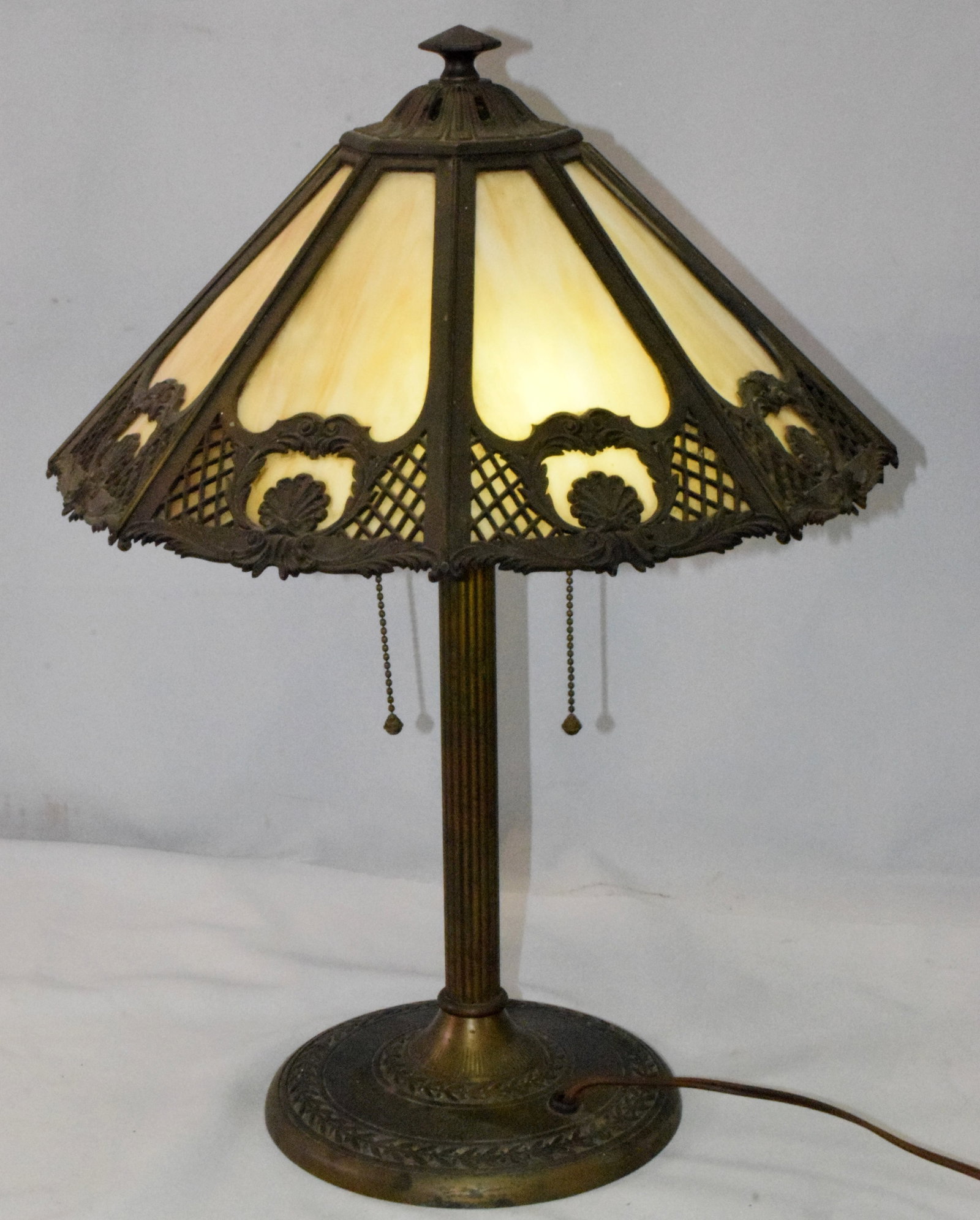 BRADLEY & HUBBARD 8 PANEL SLAG GLASS LAMP: Signed Bradley & Hubbard caramel slag glass overlay lamp. Eight angle panels with shells and lattice design overlay. Round metal base signed Bradley & Hubbard Mfg. Co.#268. ribbed column. Shade measur