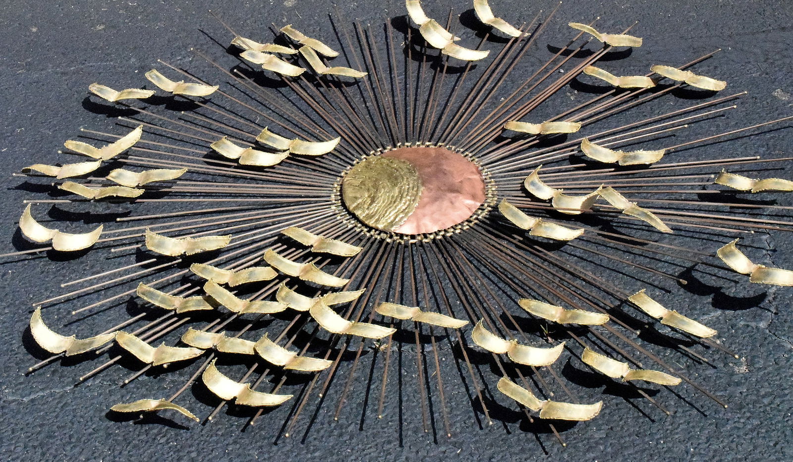 BRUTALLIST SUNBURST COPPER METAL WALL SCULPTURE: Large Brass & copper mid-century or Brutalist metal wall sculpture. Sun center with flying bird surround in flight. Original patina. 45 inches diameter. No visible signature or markings. Center sun wi