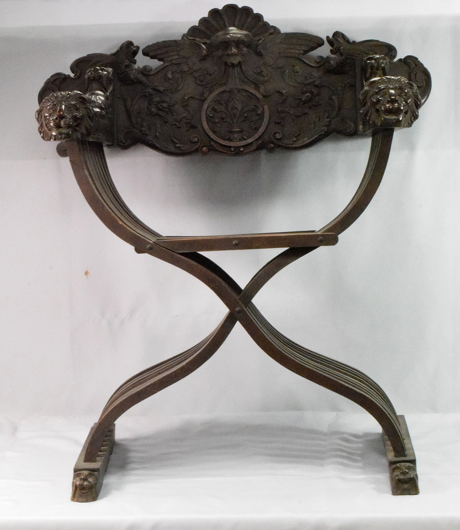 BAROQUE STYLE CARVED WALNUT SAVONAROLA CHAIR: ca 19th century. Finely carved walnut great Savonarola arm chair. carved winged dogs, north wind type lion, and lion head arms. 43 3/4 x 32 inches wide x 22 inches deep. Shipping weightapprox. 30 pond