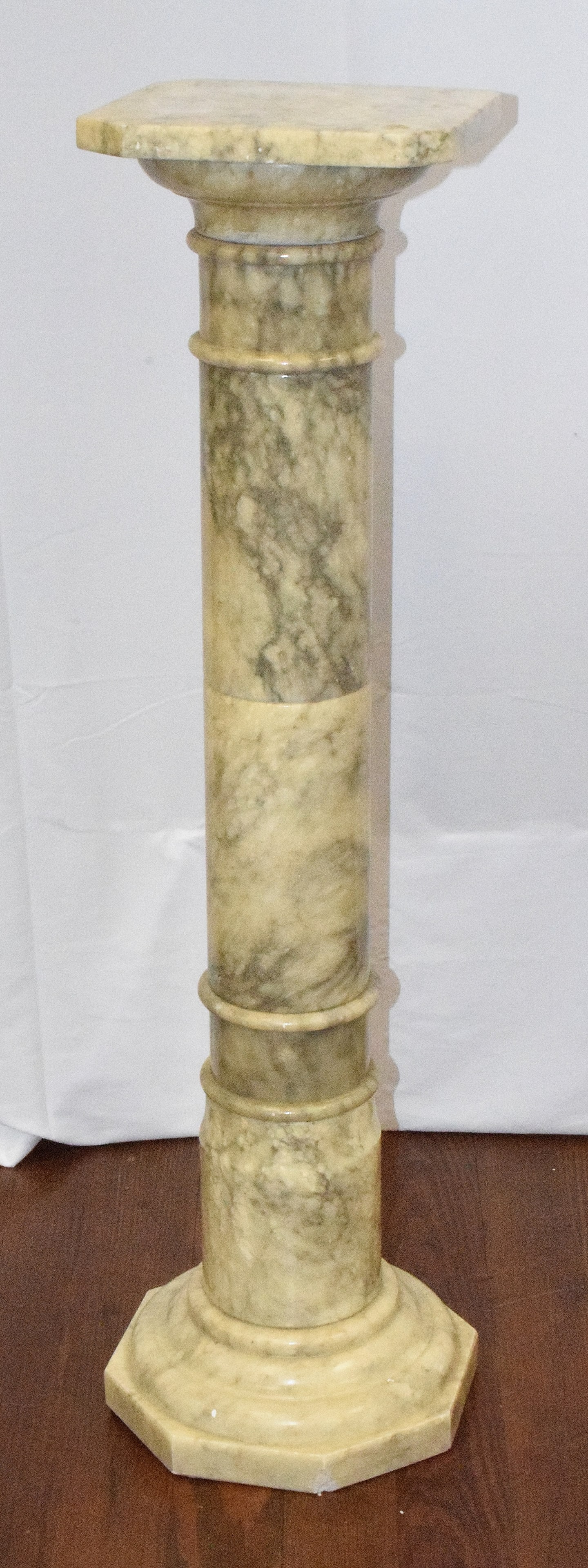 ANTIQUE ALABASTER PEDESTAL: Antique alabaster pedestal in white and gray. Octagon base with square top. 38 1/2 inches tall x 11 octagon base. Shipping weight 75 pounds. Chip on base. Visible in photo.