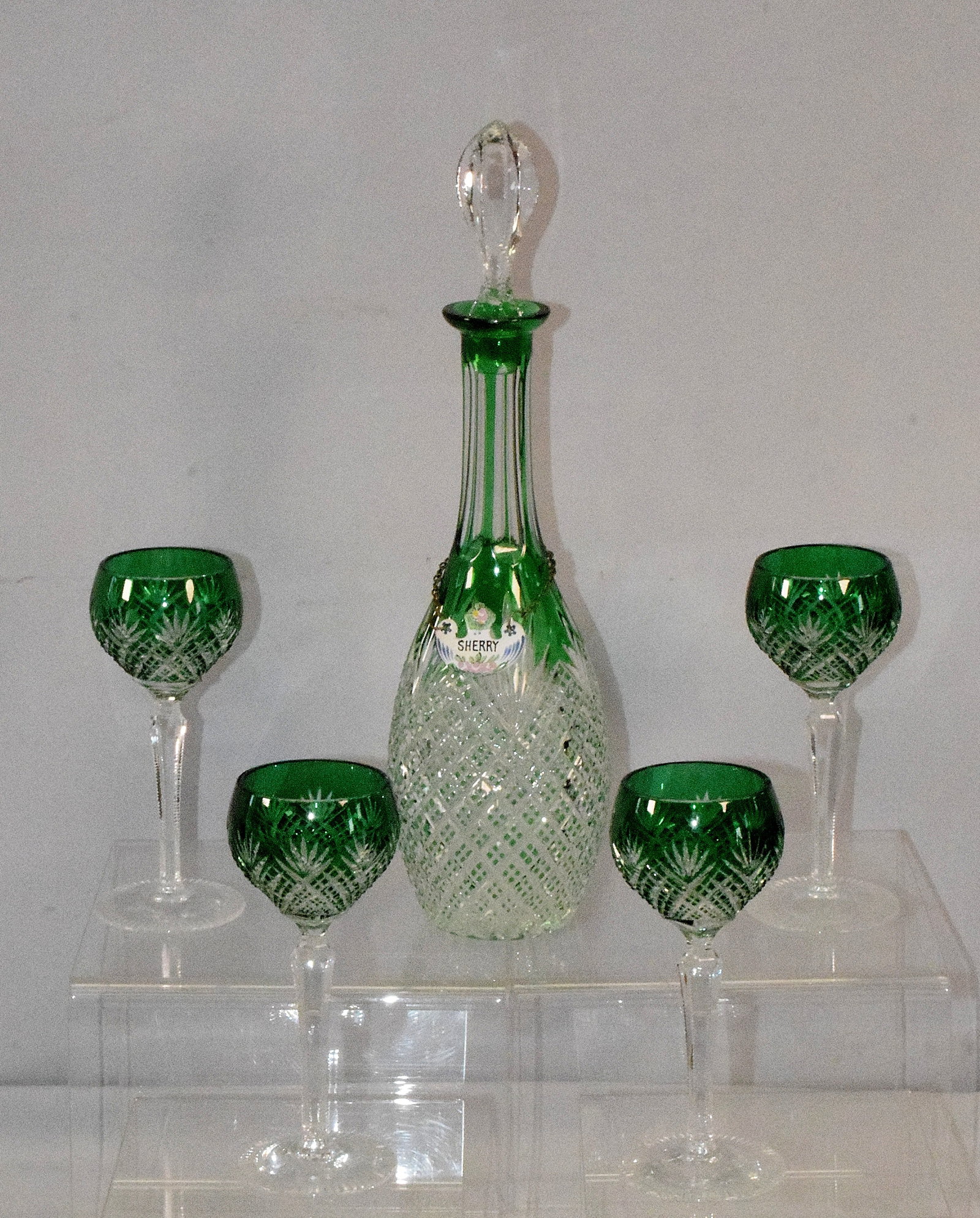 GREEN CUT TO CLEAR REXXFORD DECANTER SET: Vintage green cut to clear strawberry diamond Rexxford cut decanter with four stemmed glasses. Etched signature marks. Decanter 15 1/2 inches. Glasses 7 inches tall. Decanter with enamel sherry tag. A