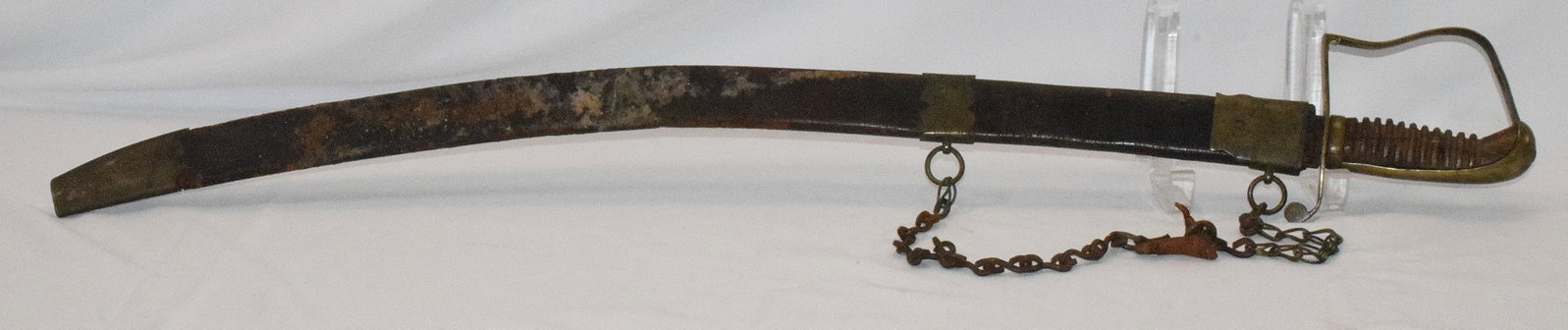 EARLY 1812 OR EARLIER SWORD OR SABRE: All original and untouched. Brass guard with wooden handle. Some bluing and gold on etched blade. Scabbard brass and leather. Hander chain does not seem original. 32 1/4 inches long.