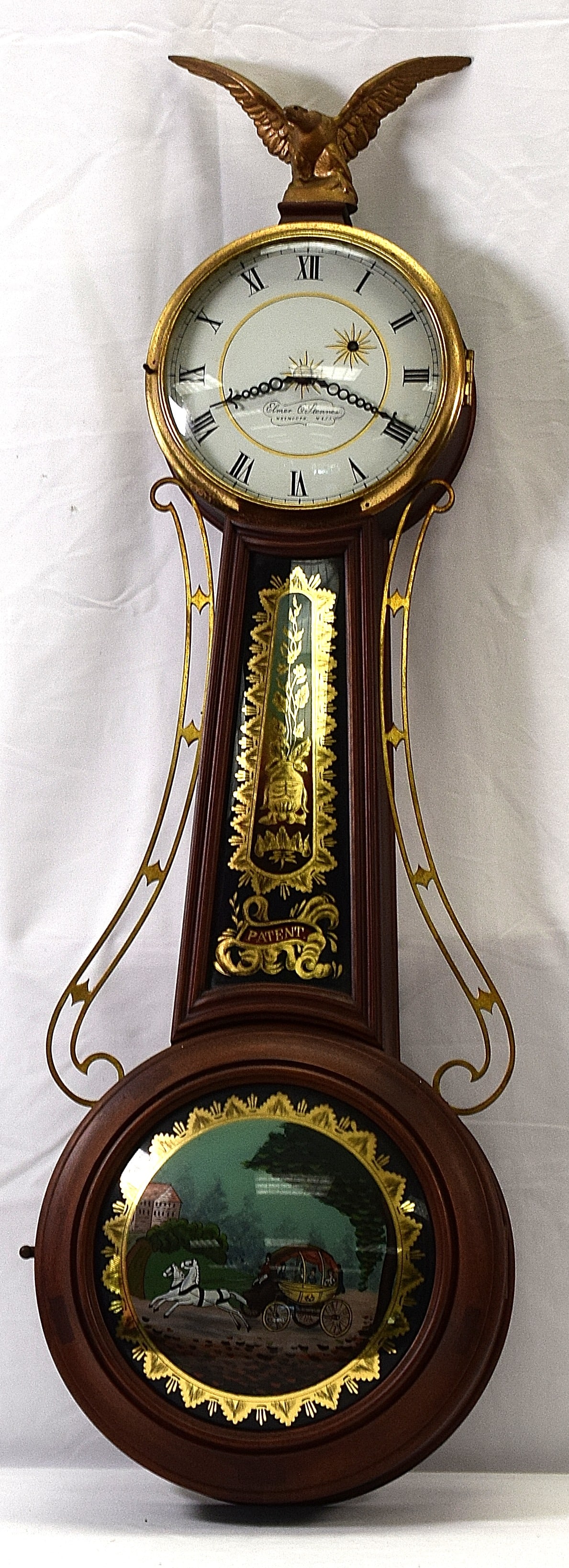 ELMER STENNES WALL BANJO CLOCK: Eagle top finial. Hand painted face and signed Elmer Stennes Weymouth Mass. Mahogany case. Reversed painted neck with patent decoration. After Simon Willard type clocks. Reversed bubbleglass coach pen