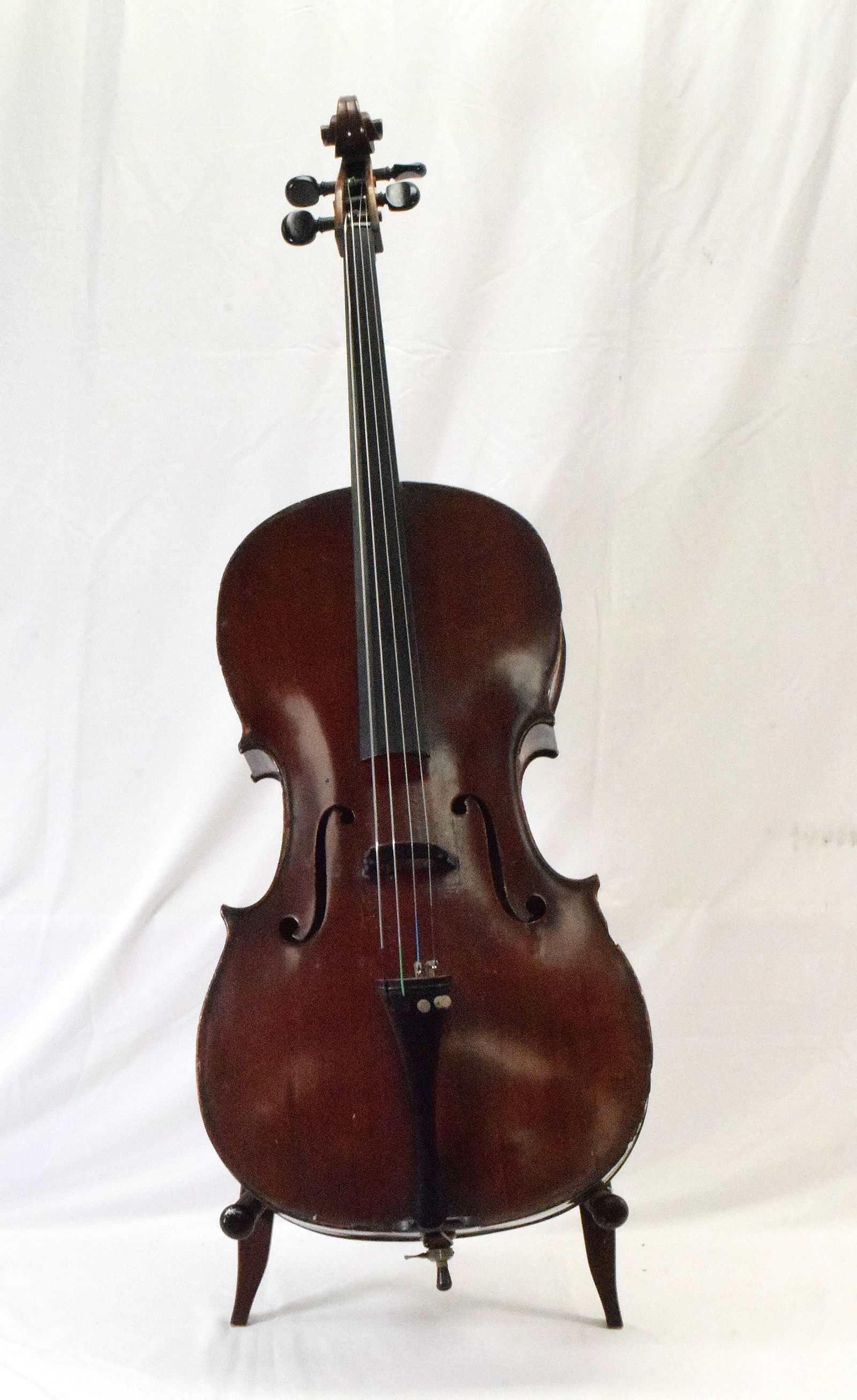 19TH CELLO: Two pieces quarter-cut maple of narrow flames ascending from treble to bass. Sides and scroll are maple similar to back. Top twp pieces spruceof narrow to medium. Varnish is dark red in color. Measure