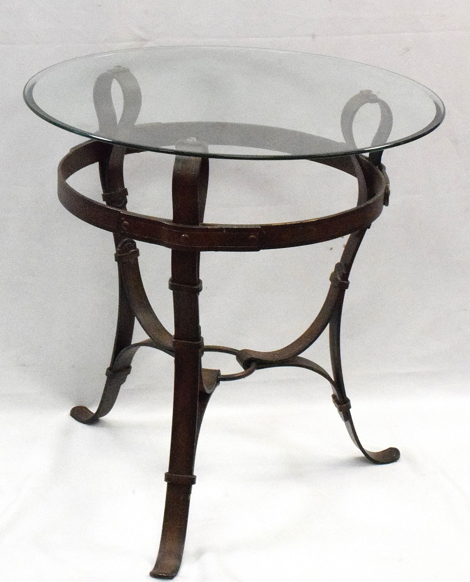 JACQUES ADNET HERMES STYLE EQUESTRIAN SIDE TABLE: Jacques Adnet (French 1901-1984) for Hermes style. Vintage Iron & glass round equestrian strap side table. 24 inches diameter bevel glass top x 24 1/2 inches tall, Iron faux brown leather strap basemo