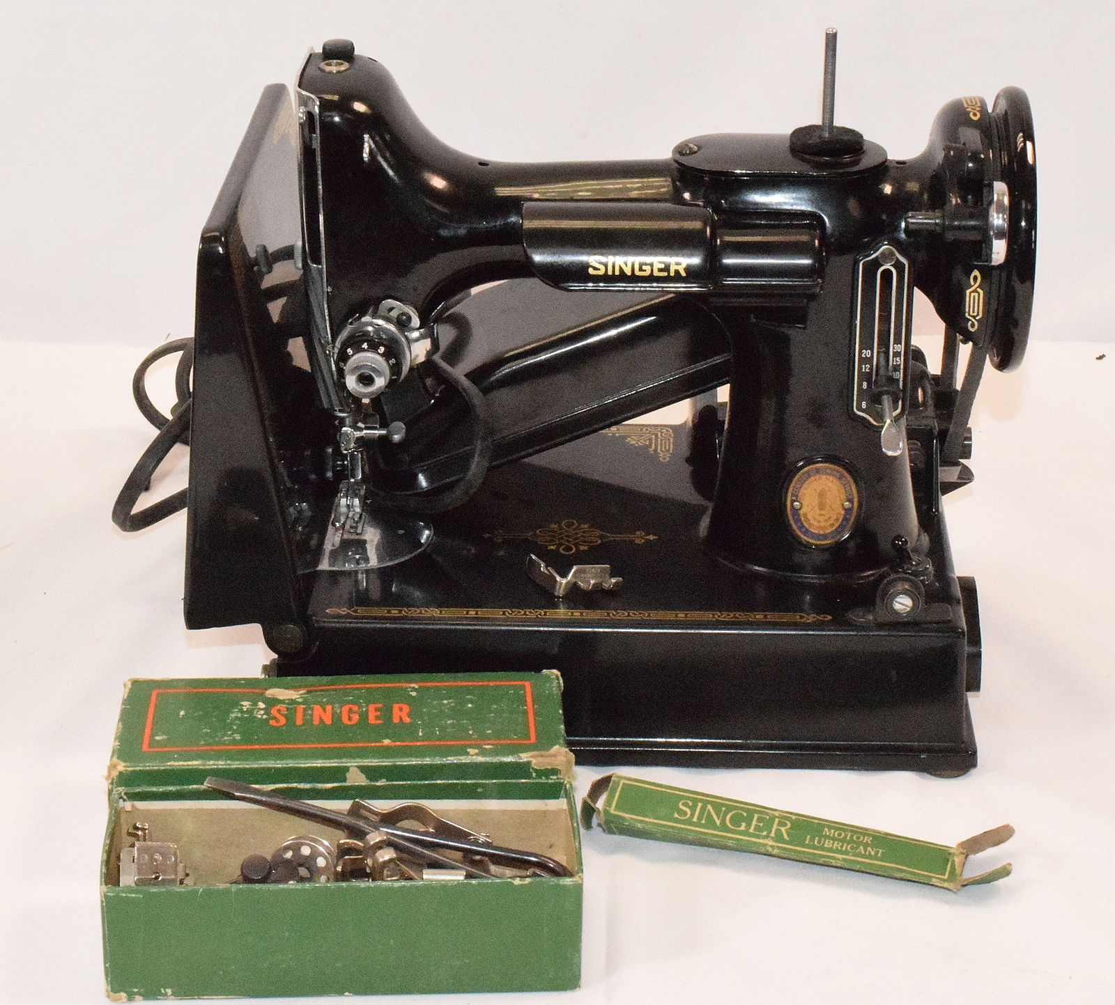 SINGER FEATHERWEIGHT SEWING MACHINE: Set comes with sewing machine from Singer and a box of sewing machine attachments. Has foot pedal, cord is detached, does not contain lightbulb. Contains serial number "AK620568" on bottom ofmachine.