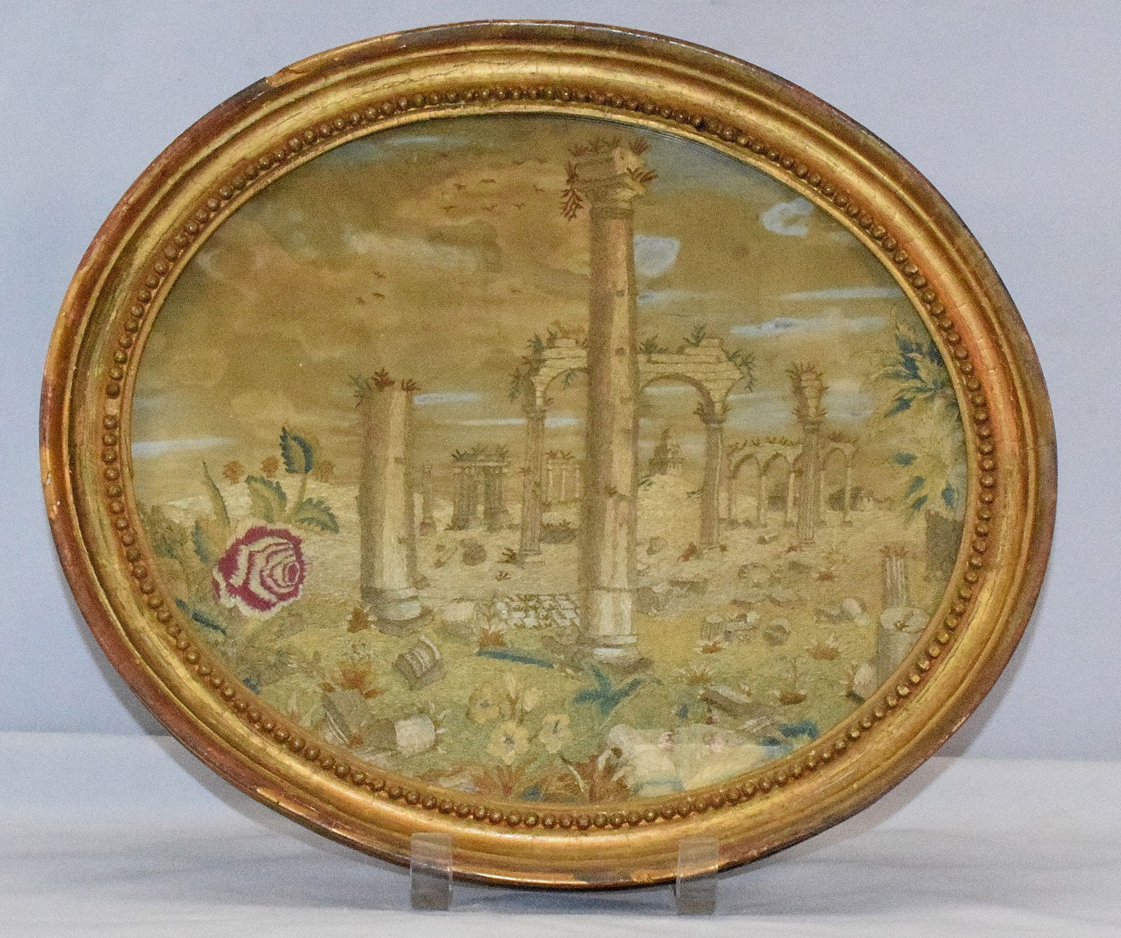 18TH/19TH SILK NEEDLEWORK EMBROILDERED PICTURE: A oval Continental Silk Needlework Embroidered and Watercolor Painted picture. Classical ruins. Frame seems original. Frame does have some layers of paint. Top of needlework work has somestaining. Fra