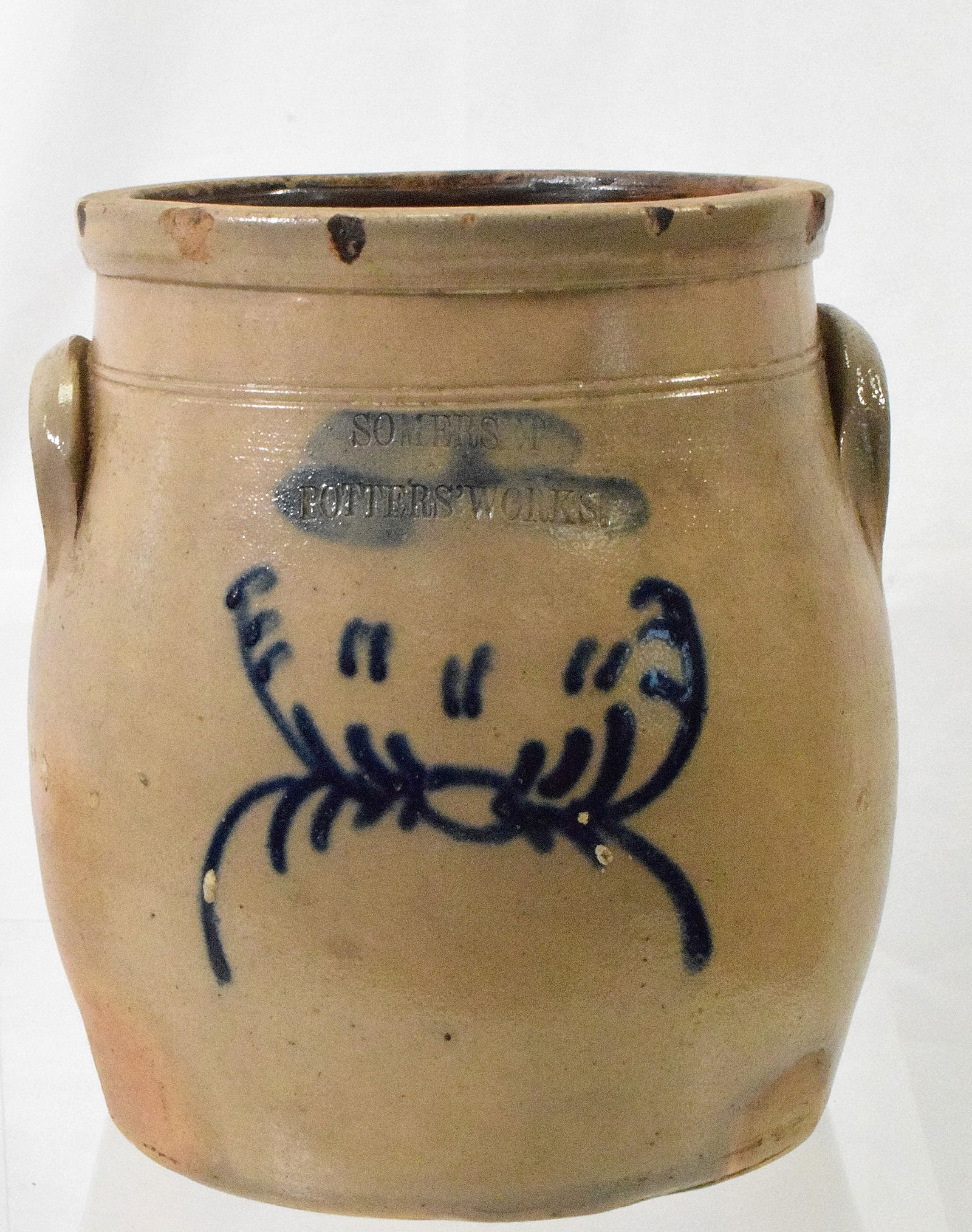 SOMERSET COBALT BLUE DECORATED STONEWARE CROCK: Ca 19th century. Impressed Somerset Potters Works with cobalt blue decoration. Two handles. Rim chips and small hairlines. 8 3/4 inches tall. Shipping weight approx. 6 pounds.