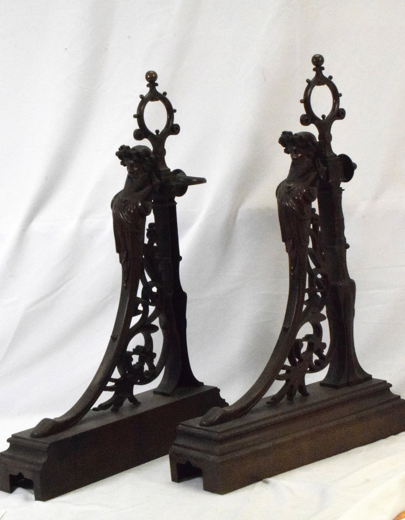 PAIR OF VICTORIAN BRASS CHENETS: Brass fireplace pair of chenets, Victorian style. Has design of mans head and upper chest facing the front, floral designs. Good condition. L: 15 1/2in W: 9 1/2in, H: 23 1/2in, Weight: 30 lbs.