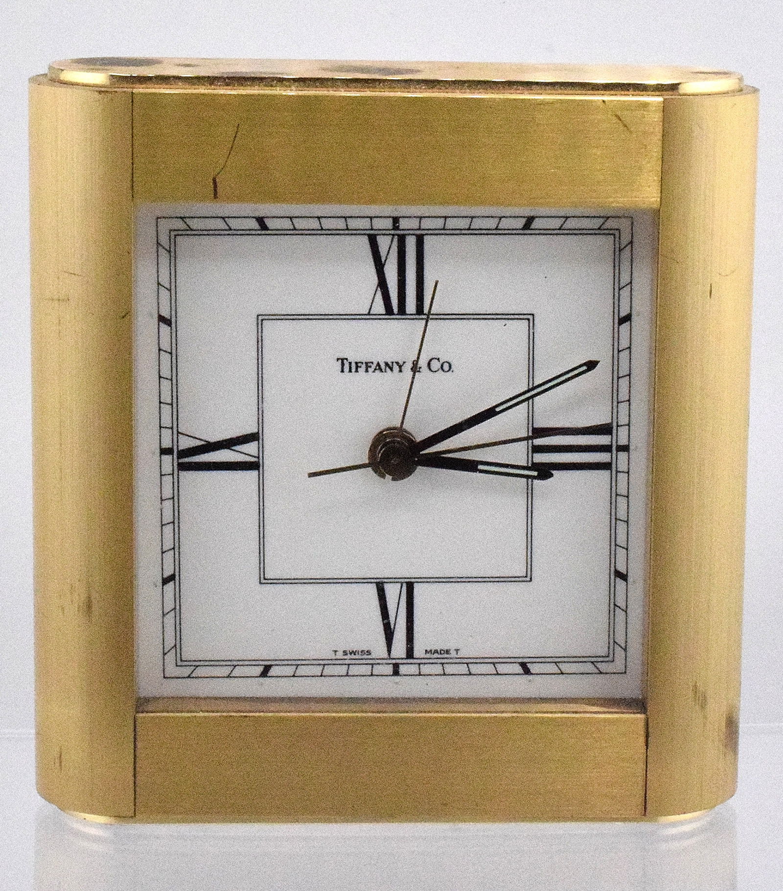 20TH CENTURY TIFFANY & CO. BRASS DESK CLOCK: Tiffany & Co. brass desk clock, decent condition. Clock doesn't work. 4 inches long and 4 inches wide. Approx. 5 pounds.