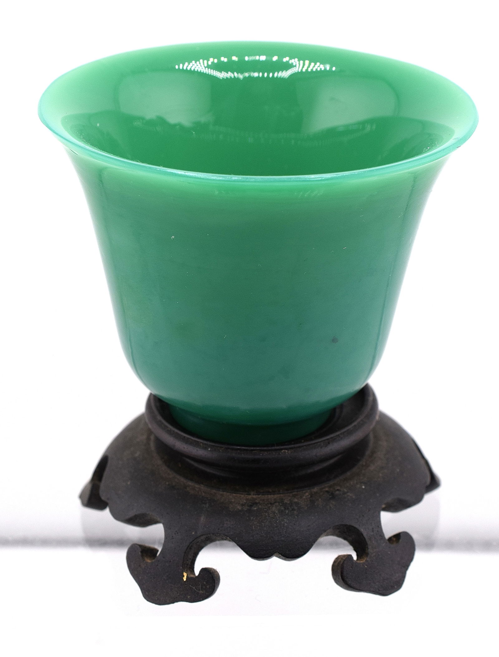 WOODEN BASED CHINESE GREEN JADE CUP: Chinese green jade cup, has wooden base, age is unknown, small flea bite around rim, 2 3/4 inches long x 3 1/4 inches wide rim diameter. Shipping weight approx. 1 pound.