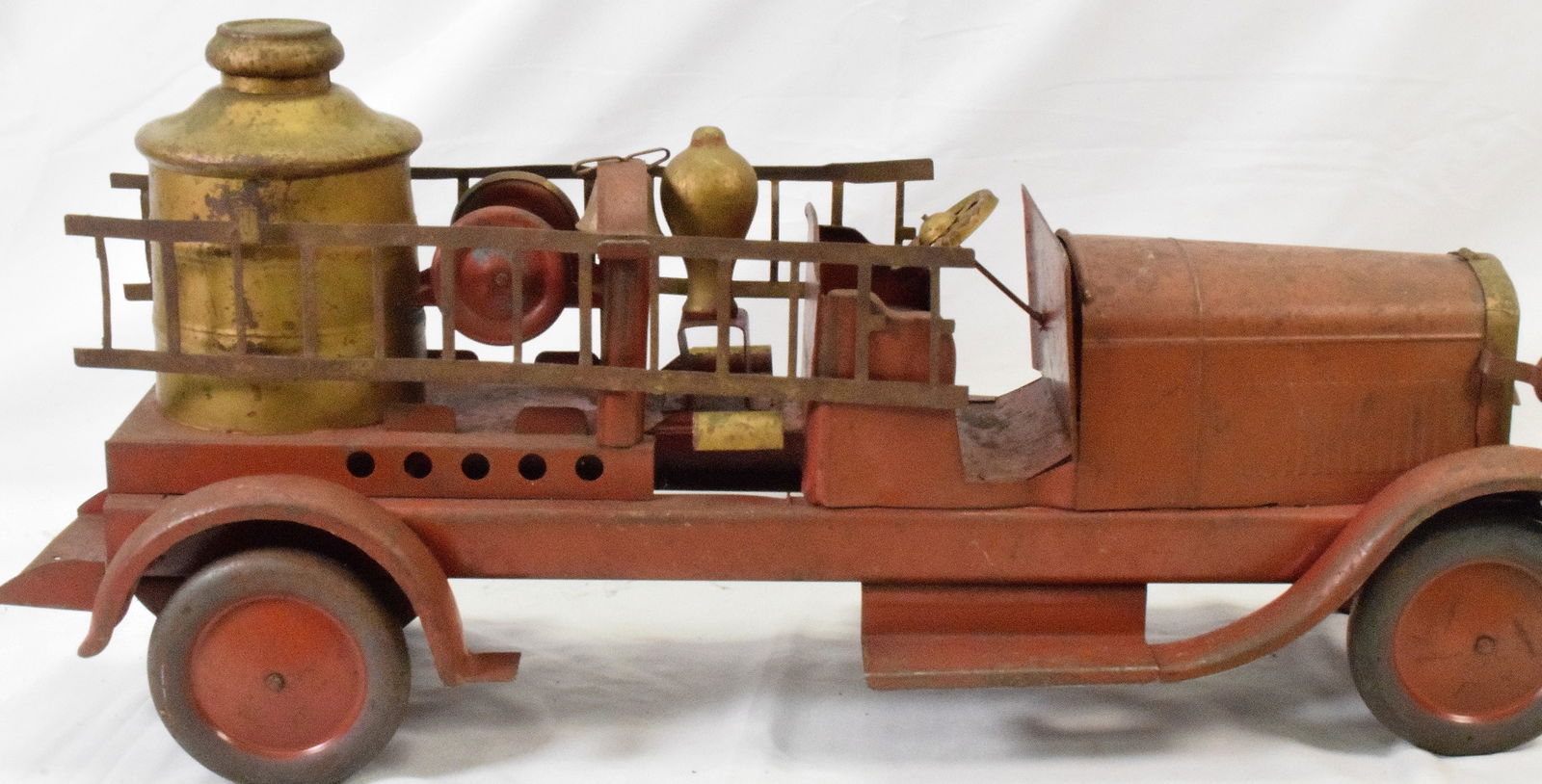 TURNER PRESSED STEEL FIRE PUMPER TRUCK: Antique painted pressed steel, large scale fire truck with all original components including painted wood stema dome, ladders, and bell, 28" long. Some paint loss and wear.