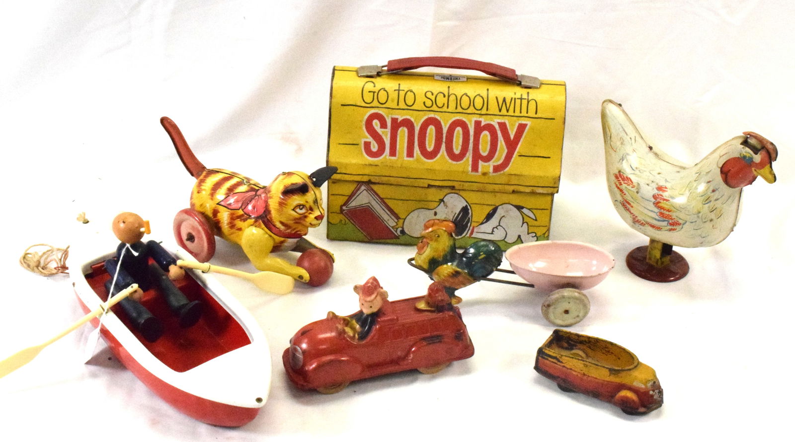 SEVEN MISC. VINTAGE AMERICAN TOYS: 1) Wyandotte Coast Guard pressed steel red and white row boat pull toy with wooden Popeye looking sailor, plastic oars. Measures 11 inches long x 4 1/4 inches wide. Good condition. 2) 1930's SunRubber