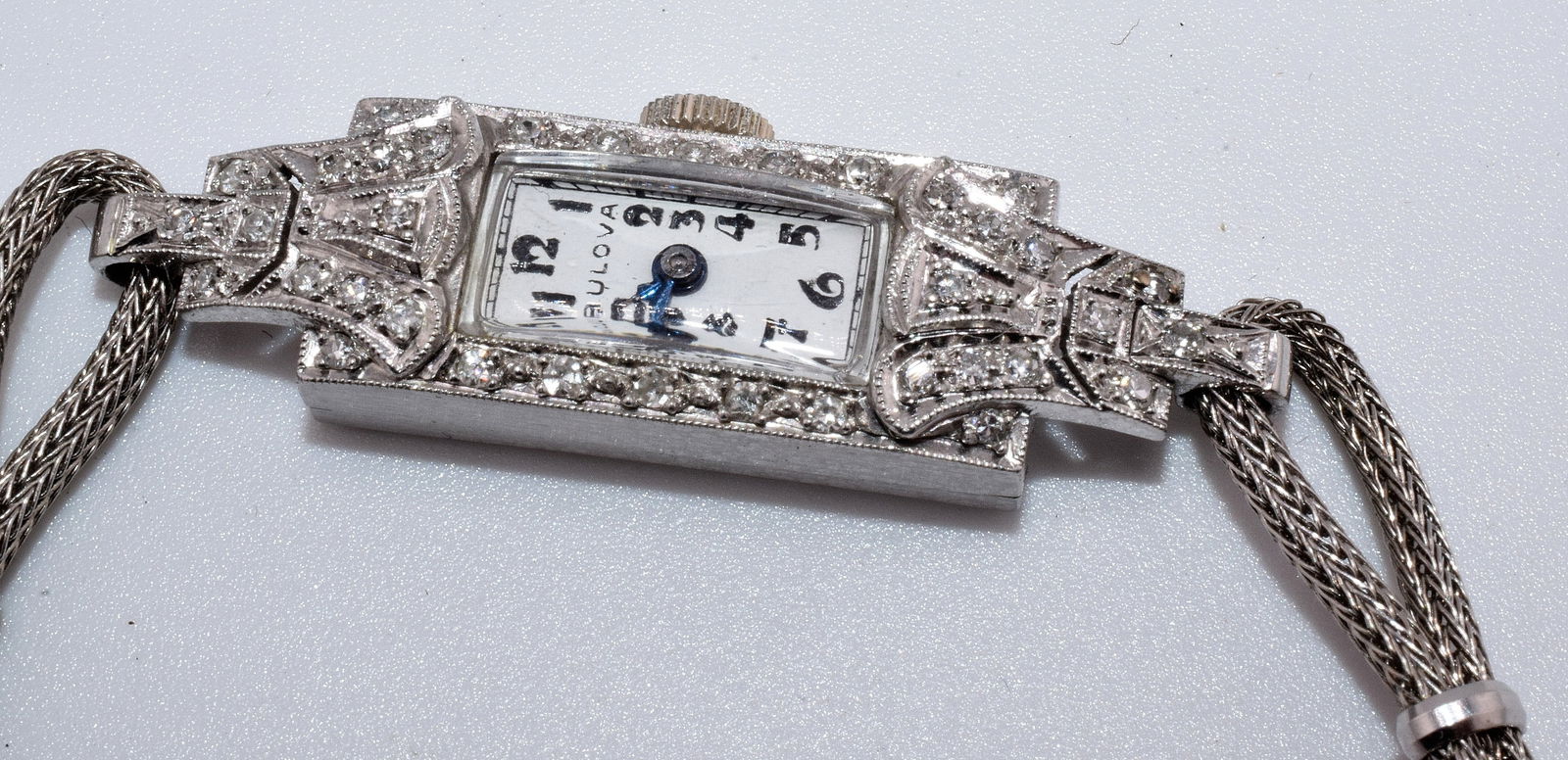 LADY'S PLATINUM & DIAMOND BULOVA WRIST WATCH: Ca 1930's Art deco lady's platinum & diamond Bulova wrist watch with a Longines Swiss movement. 17 jewels. Watch is working. Watch is platinum but the band is a Spidel. Approx. 36 small white round di