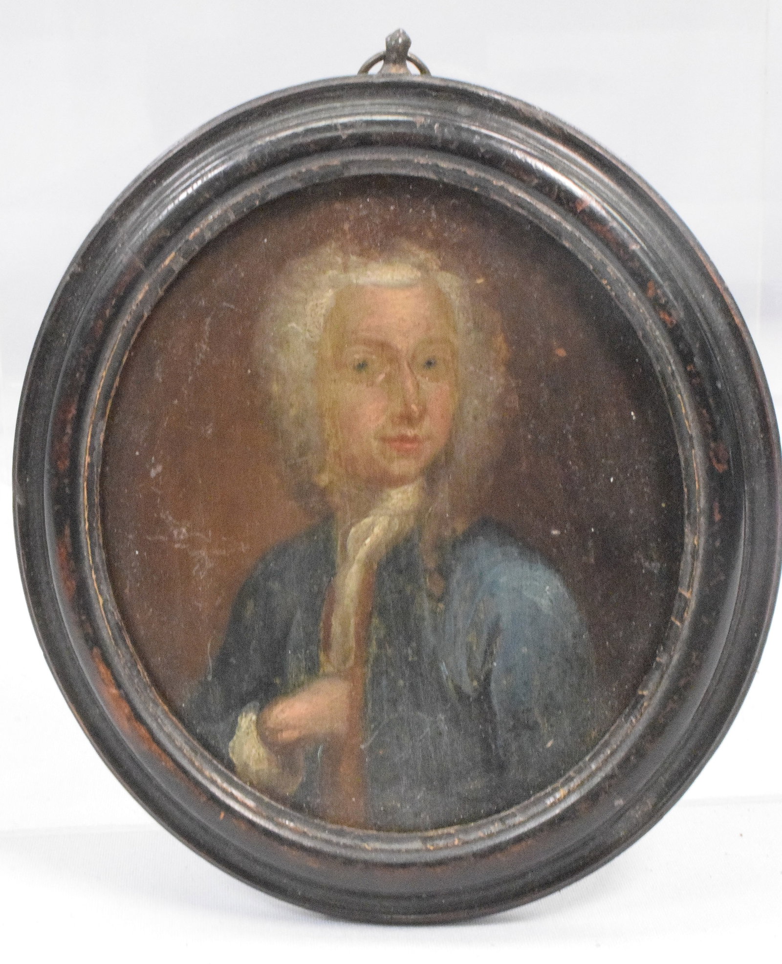 EARLY OVAL MINIATURE PAINTING: 18th century. Miniature painting on wood. Oval in original frame. Male figure in blue coat. Likely European. Good condition. The Estate of Nicholas Mitropoulos 1952-2025.