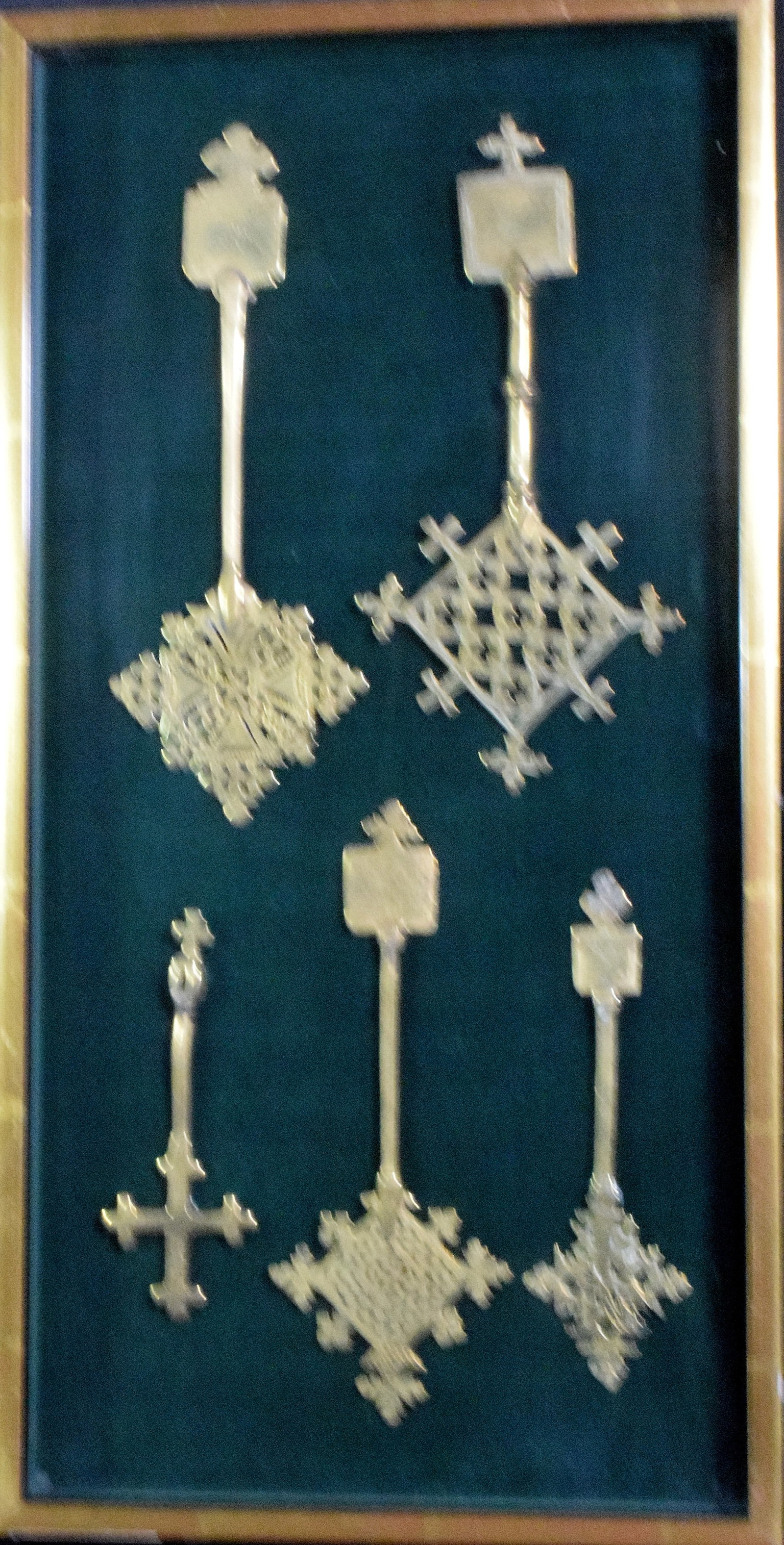 SHADOW CASE WITH 5 ETHIOPIAN PROCESSION CROSSES: Shadow case frame with 5 Ethiopian Orthodox church procession Coptic cross. Ethiopian Coptic Crosses. ca 19th century. Size range 10 3/8 - 61/4 inches high. Featuring a various designs. Frame22 1/2 in