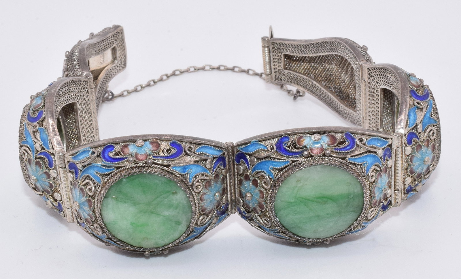 CHINESE ENAMEL SILVER FILIGREE JADE BRACELET: Chinese Cloisonne Enamel silver filigree bracelet Six links or panels with four having carved jade inserts carved designs with enamel cloisonne floral surrounds or halos. The remaining to having ename