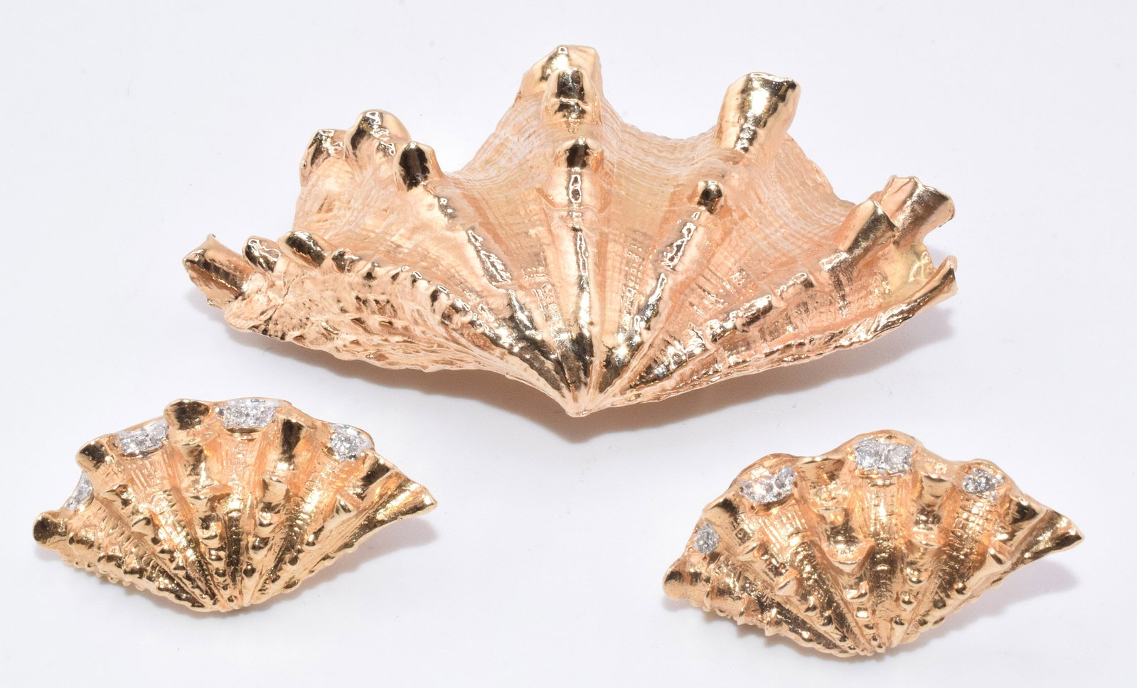 14K GOLD SCALLOP PENDANT WITH MATCHING EARRINGS: 14k yellow gold meticulously crafted in the shape of a textured scallop shell. 2 1/4 inches x 1 1/4 inches. Tested 14k. Approx. 15.13 DWT. Marked 14k. 2) Matching earrings Screw back pierced
