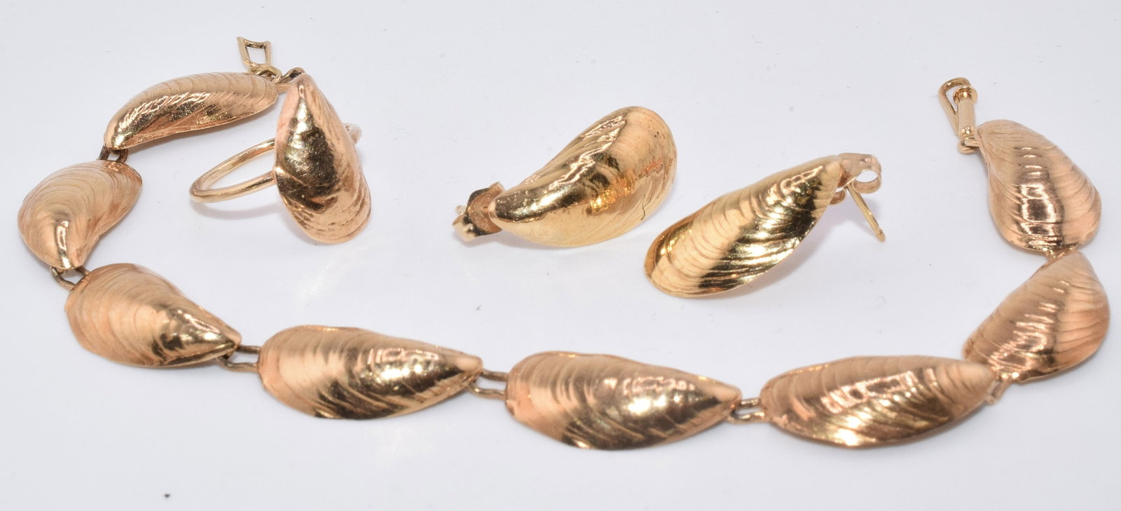 SET OF 14K GOLD JEWELRY SET: Set includes: pair of earrings, a ring and a bracelet. 14 karat, 7.00 DWT. Each piece has a scallop shell design on it. Not signed or marked. Good condition. Earring: 1/2" x 1/4", RIng: 1/2" x 1/2",