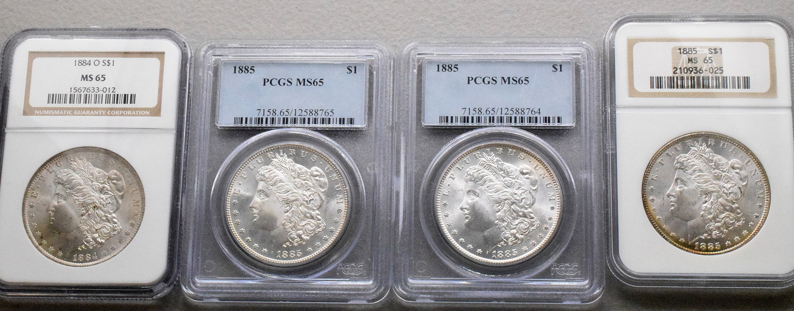 4 GRADED US SILVER MORGAN DOLLARS: 4 each graded MS-65. Dates included 18840, 1885, 1885, 1885s. White's Auctions will not take credit cards on gold jewelry, gold coins, silver or bullion and does not grade coins