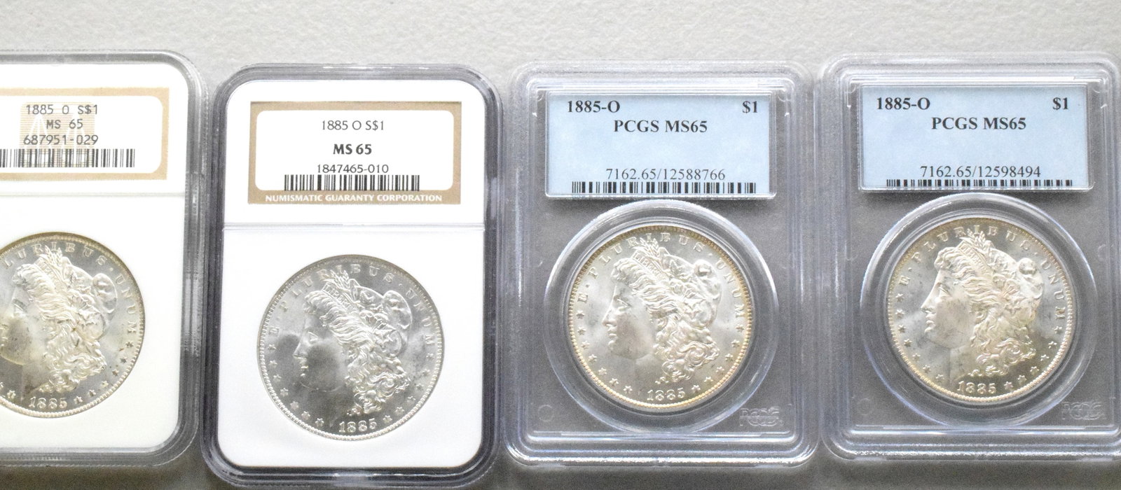 4 GRADED US SILVER MORGAN DOLLARS, 1885o: 4 each graded MS-65. Each dated 1885'o. White's Auctions will not take credit cards on gold jewelry, gold coins, silver or bullion and does not grade coins