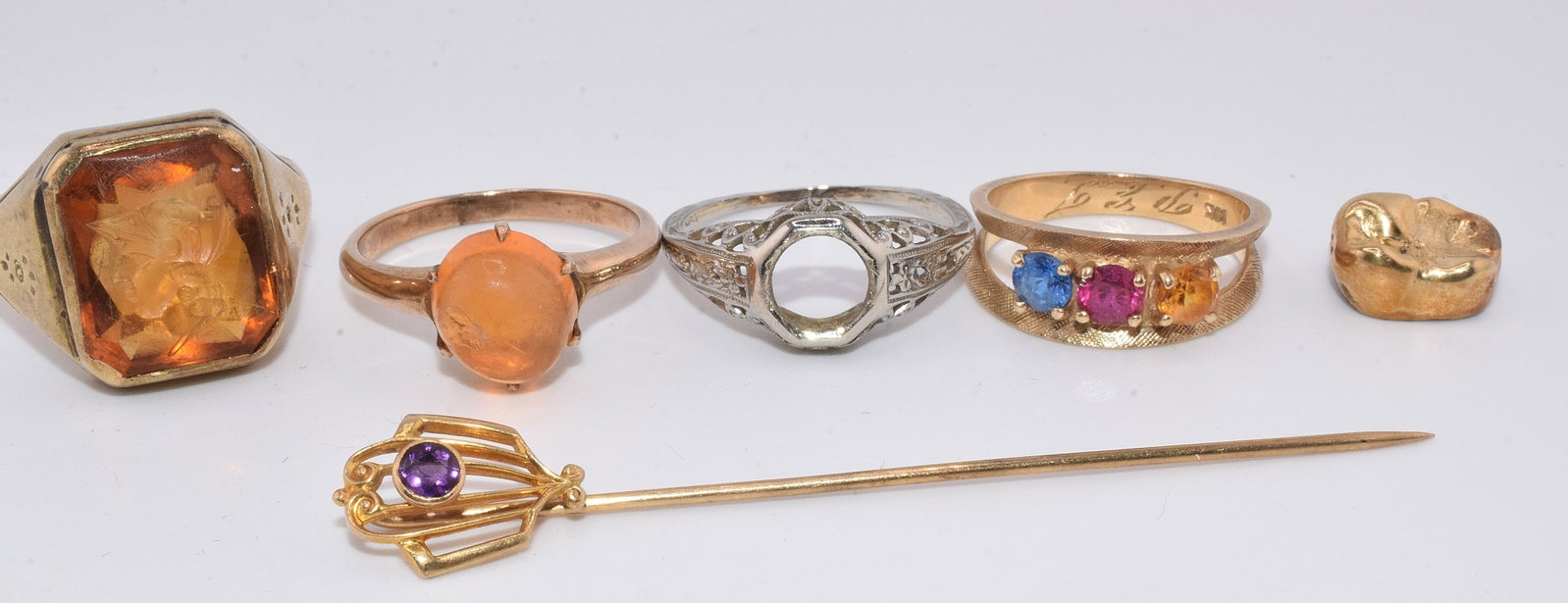 ASSORTED GOLD JEWELRY GROUPING: Consists of 6 items. As is. 1) 14k mens intaglio ring with a chip on intaglio. Tested 14k. 5.19 DWT. 2) 14k tested gold and orange cabachon topaz type gemstone. Gemstone with crack. 2.30 DWT. 3)14k