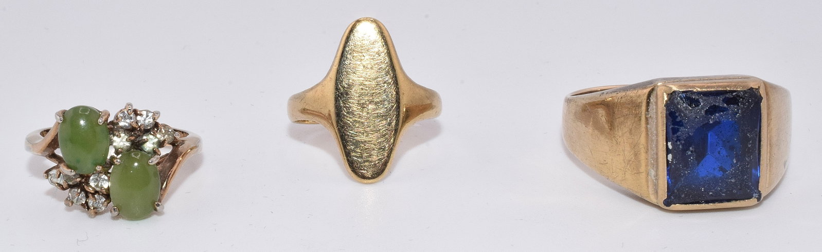 (3) GOLD RING GROUPING: Assorted gold rings. Total of three. Consists of 1) 14k ring with blue stone or glass stone. Approx. 6.47 DWT. Wear to blue stone. As is. 2) two 10k rings and one with small diamonds andjade. The