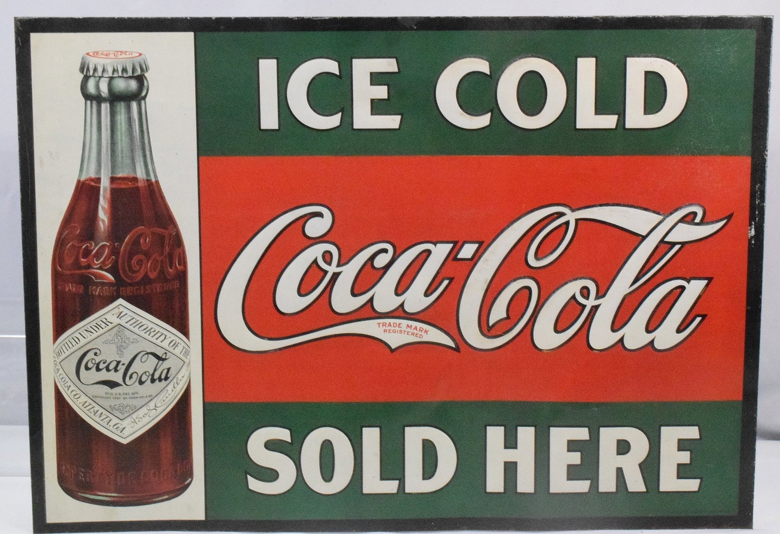 COCA-COLA TIN LITHO SIGN: Trademarked coca-cola sign "Ice Cold Sold Here", litho on metal, with image of 1908 bottle. Some denting around sign. Good condition. 19 1/2" H x 27"L. 2lbs.